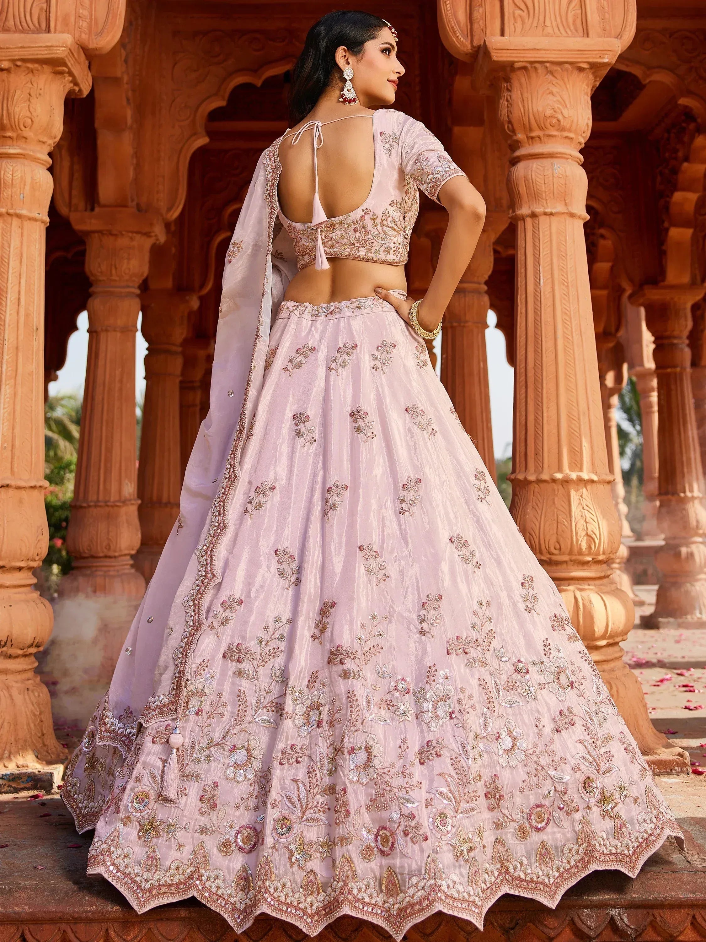 Elegant pink embroidered lehenga choli with floral motifs, perfect for Indian weddings and festive occasions.