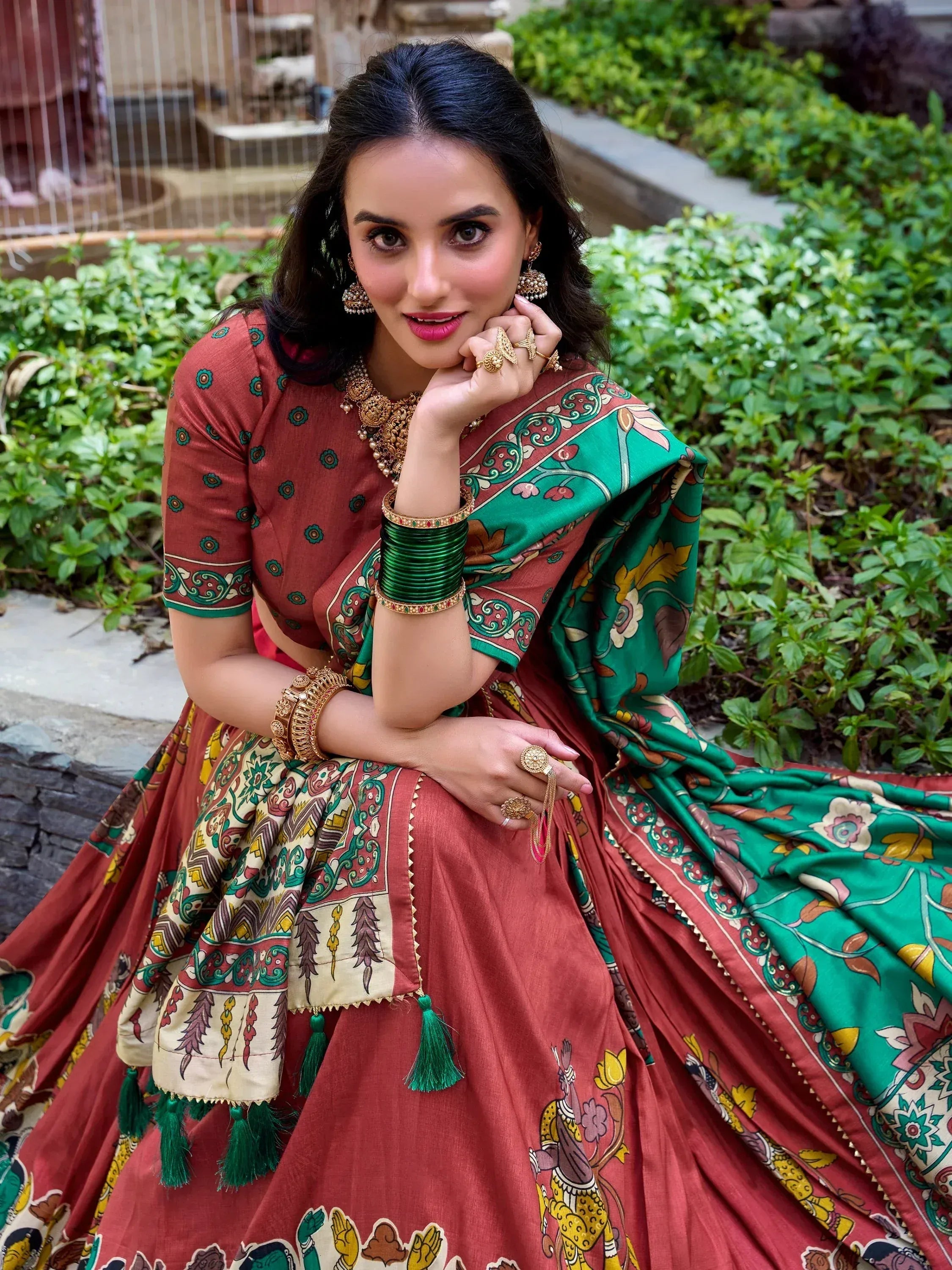 Woman in designer lehenga choli with green dupatta, ethnic print, and traditional jewelry