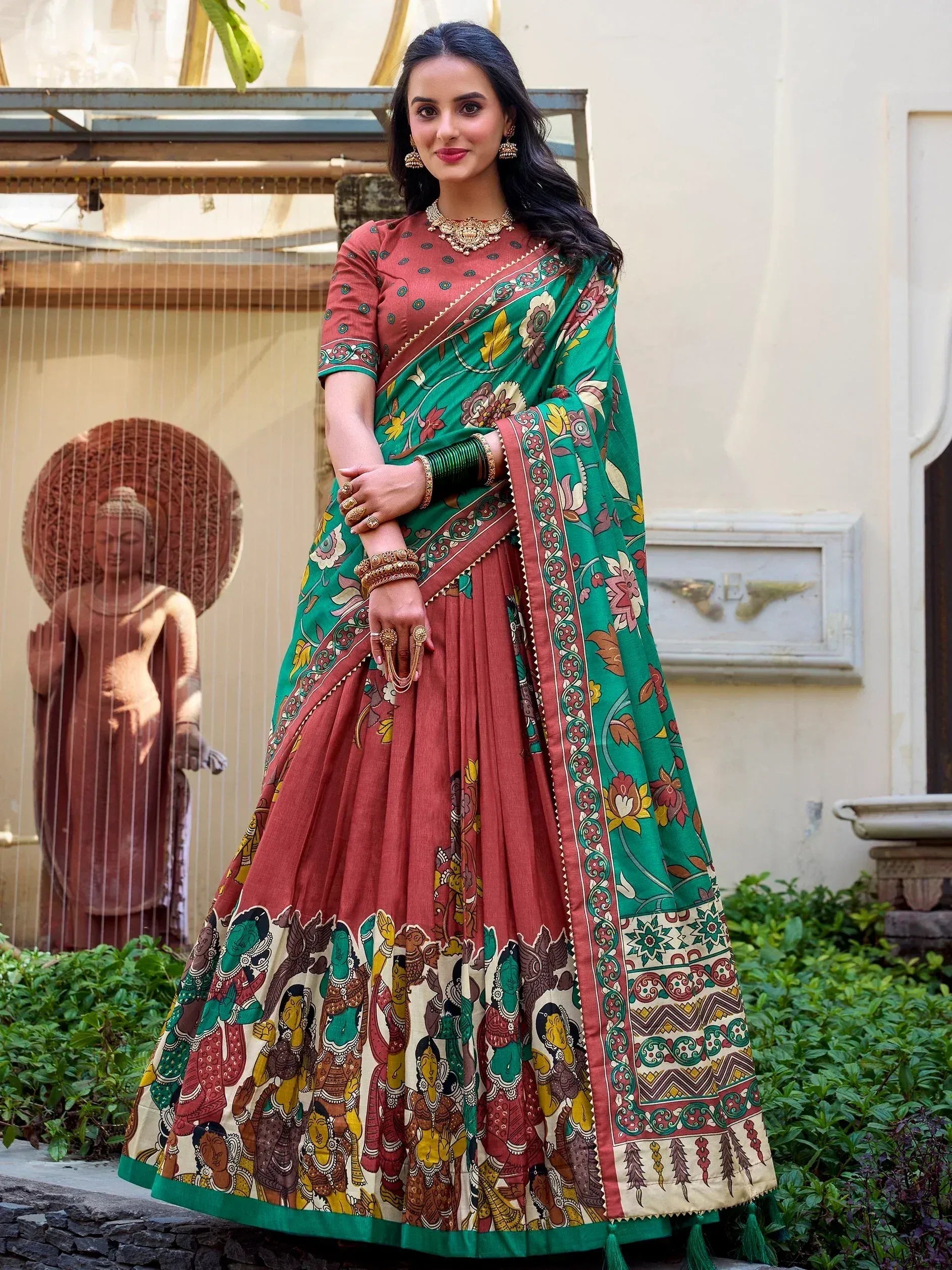 Woman in vibrant green and maroon printed lehenga choli with floral and tribal motifs, perfect for Indian ethnic occasions.