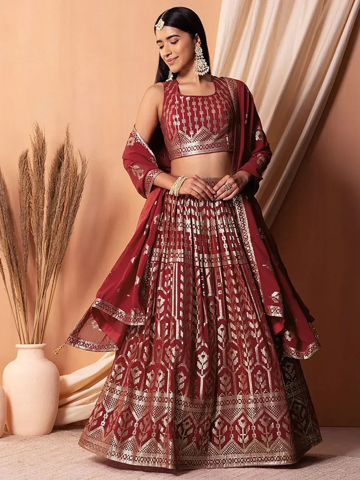 Maroon embroidered lehenga choli with gold detailing, perfect for Indian weddings and festive occasions