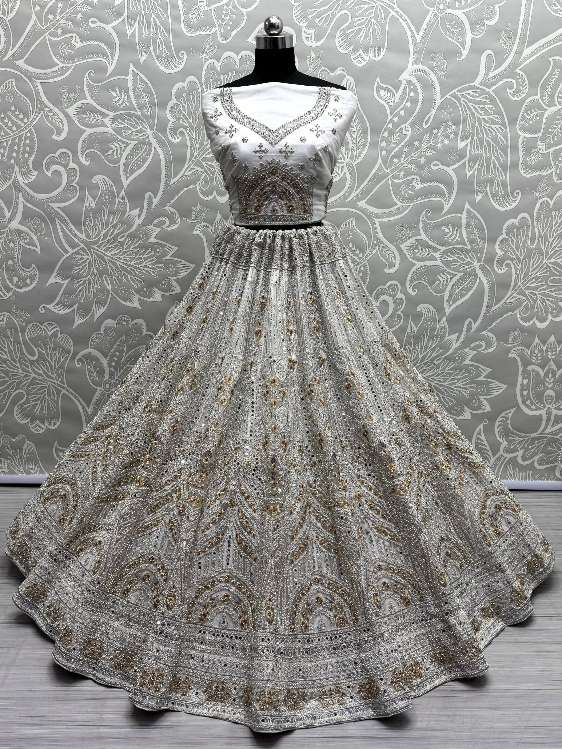 Elegant white lehenga choli with intricate gold and silver embroidery, perfect for Indian weddings and festive occasions.