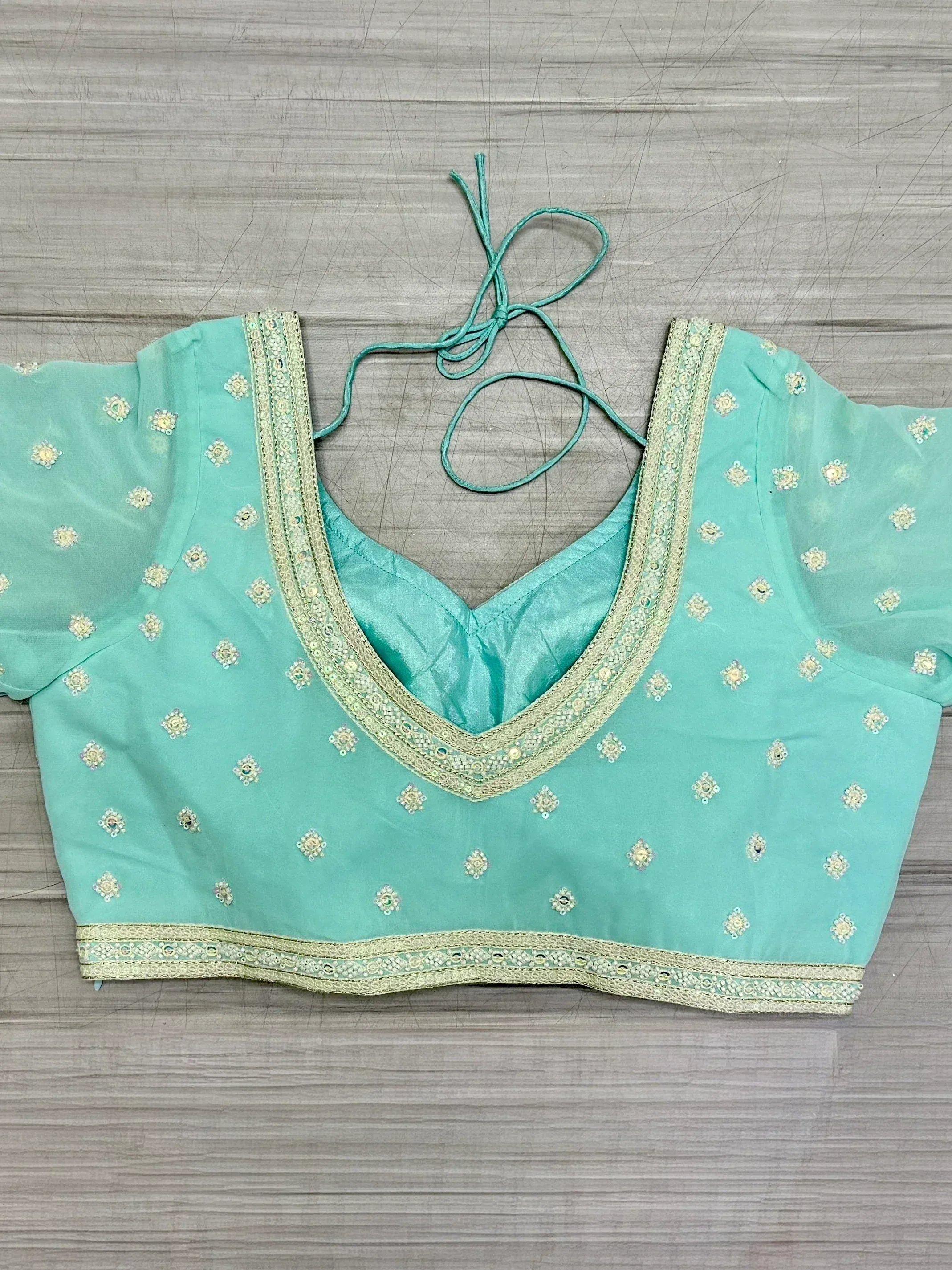 Mint green ethnic blouse with gold embroidery and tie-back detail for lehenga choli