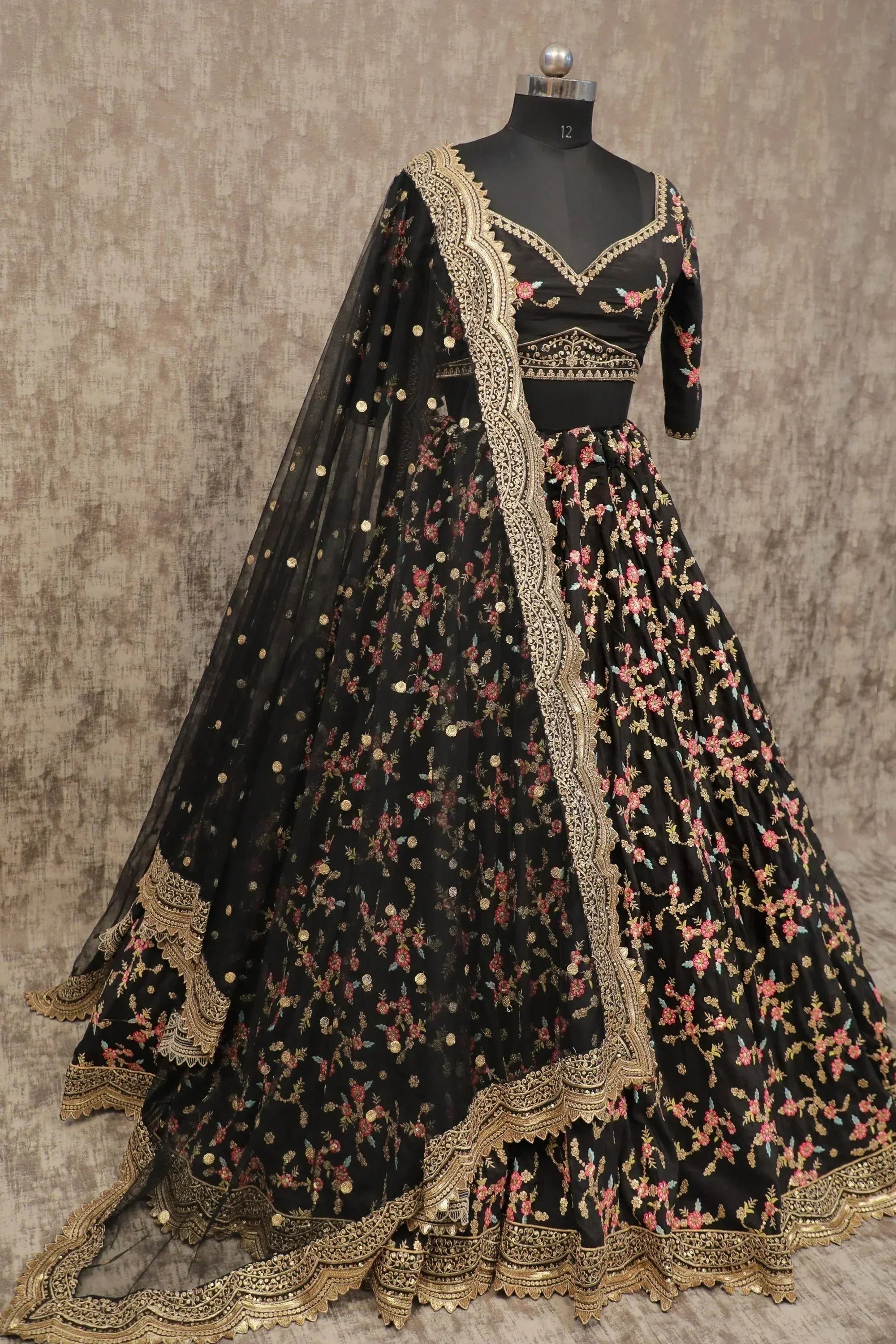 Black floral embroidered lehenga choli with gold detailing and sheer dupatta, perfect for Indian ethnic occasions.