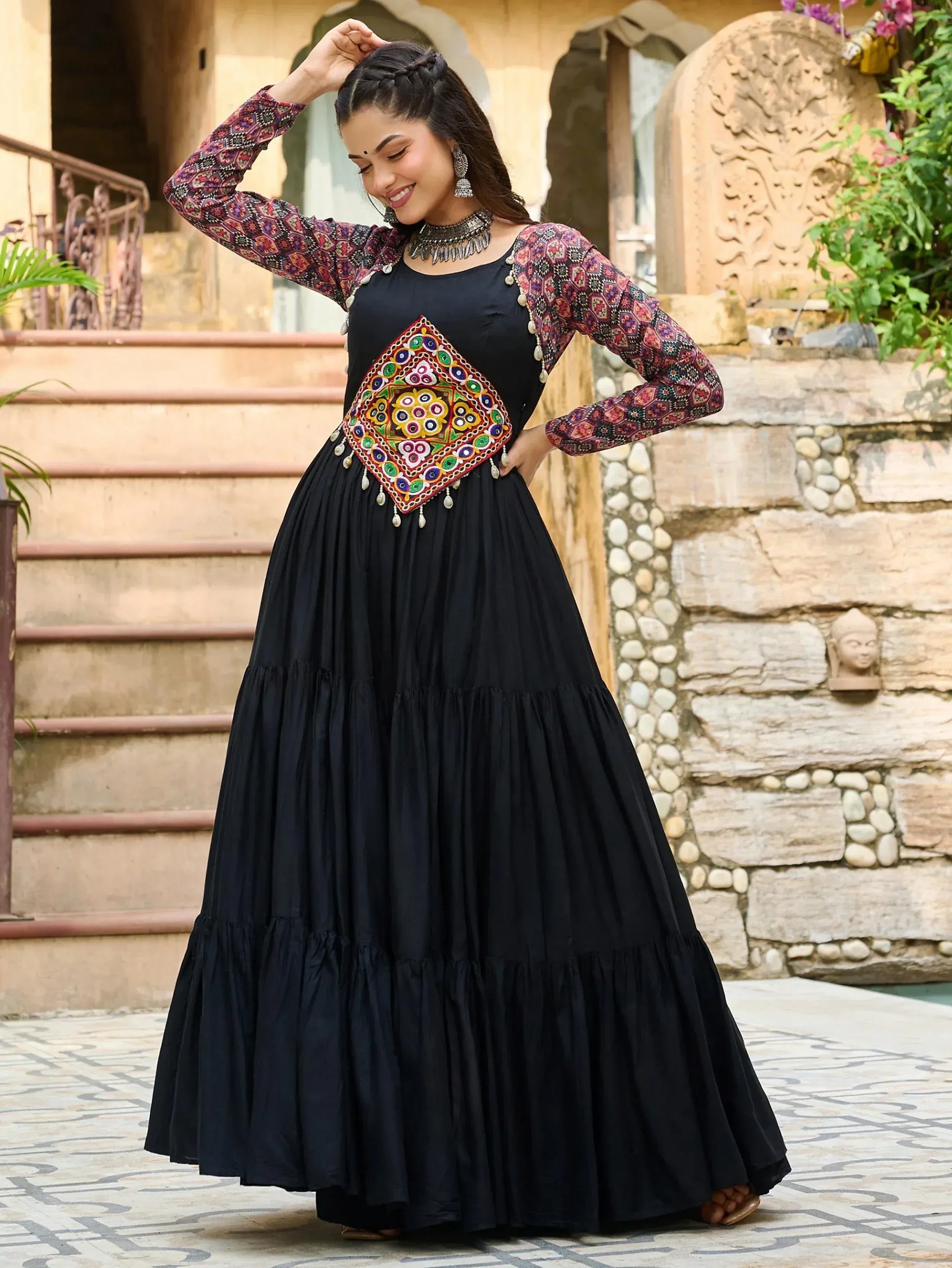 Black ethnic gown with colorful mirror work and printed sleeves, perfect for Indian festive occasions.