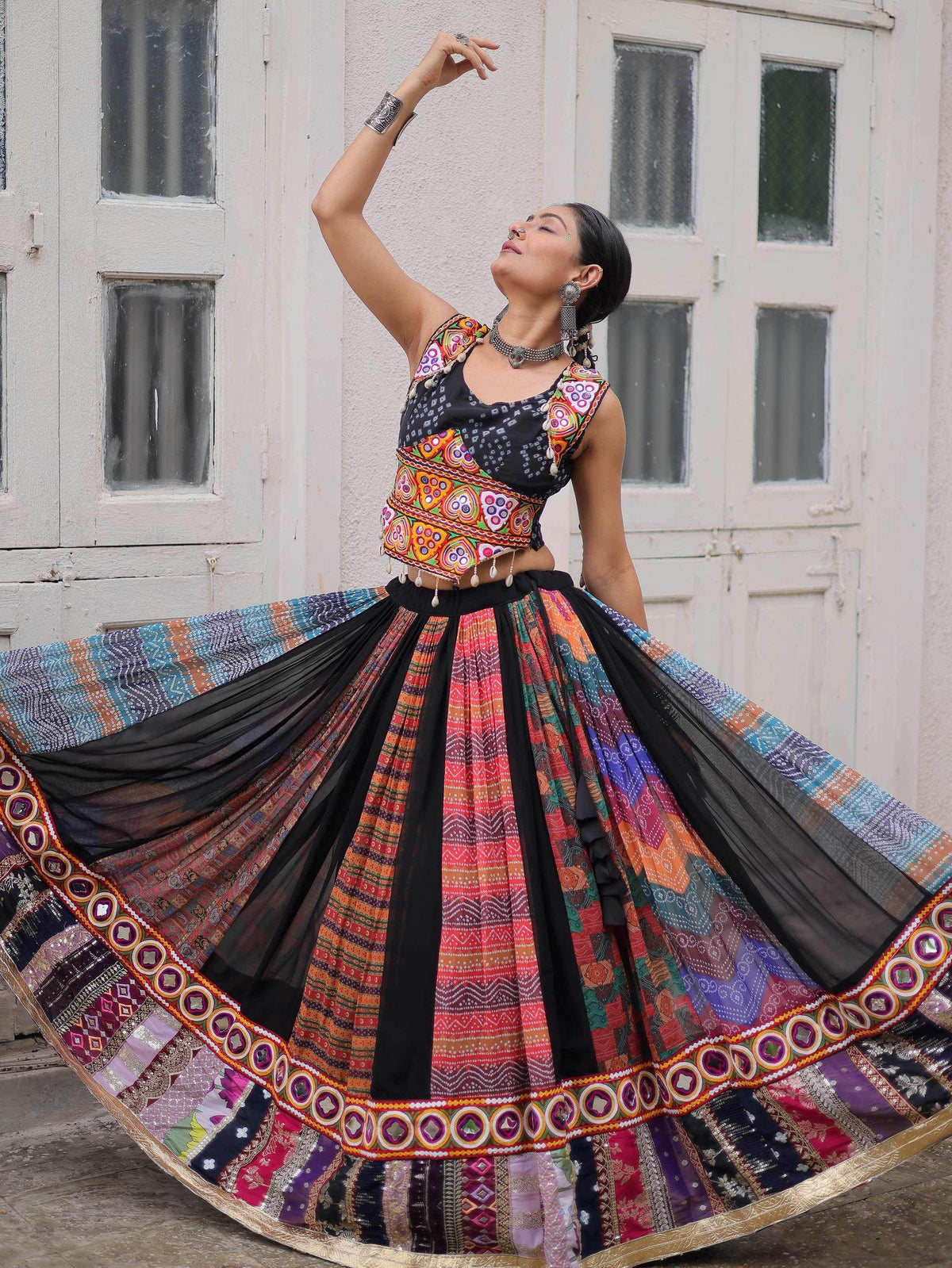 Woman in colorful Indian ethnic lehenga choli with mirror work, dancing outdoors