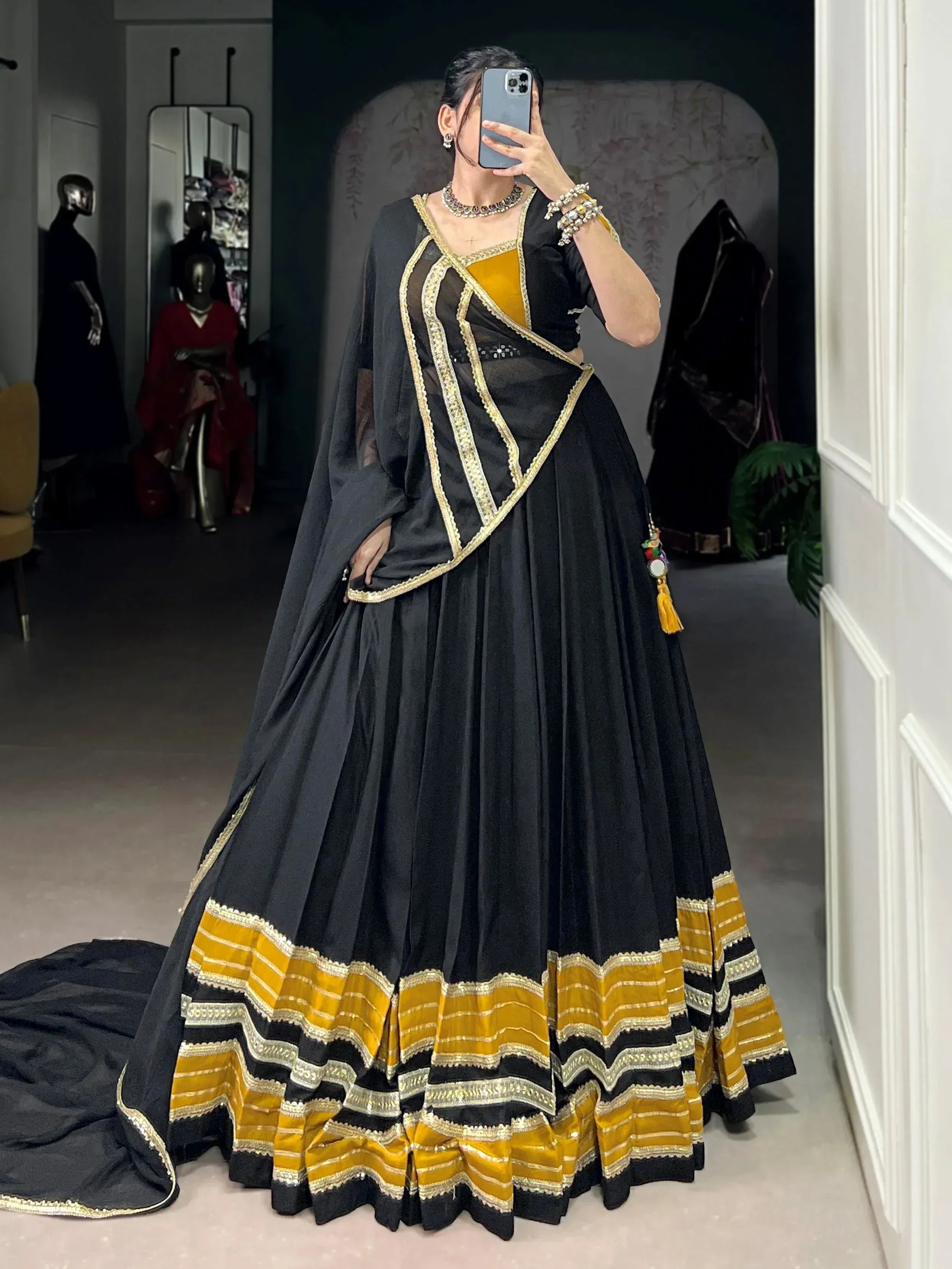 Black and gold ethnic lehenga choli with intricate border detailing, perfect for festive occasions.