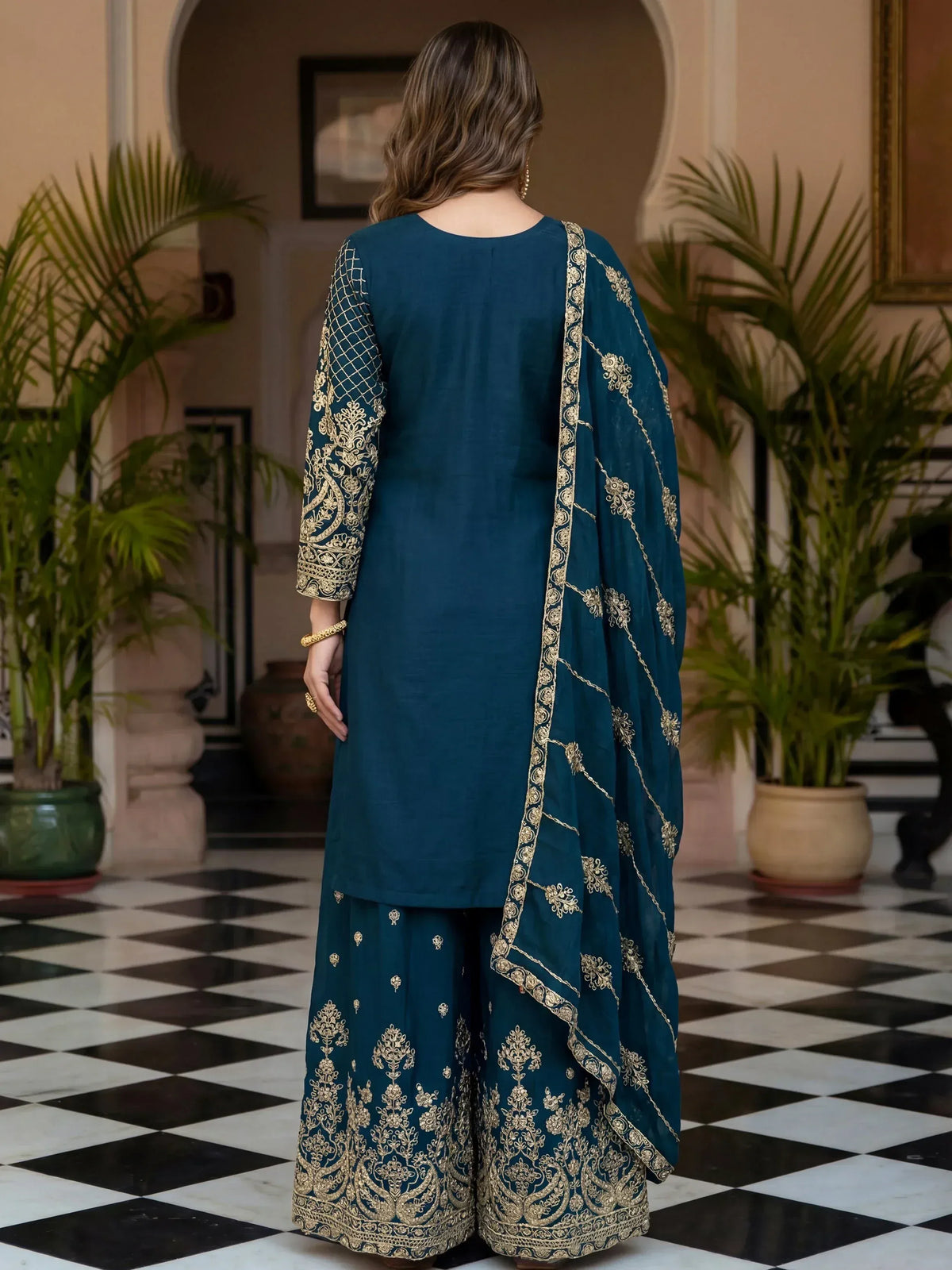 Teal Indian ethnic salwar kameez with gold embroidery, back view on checkered floor