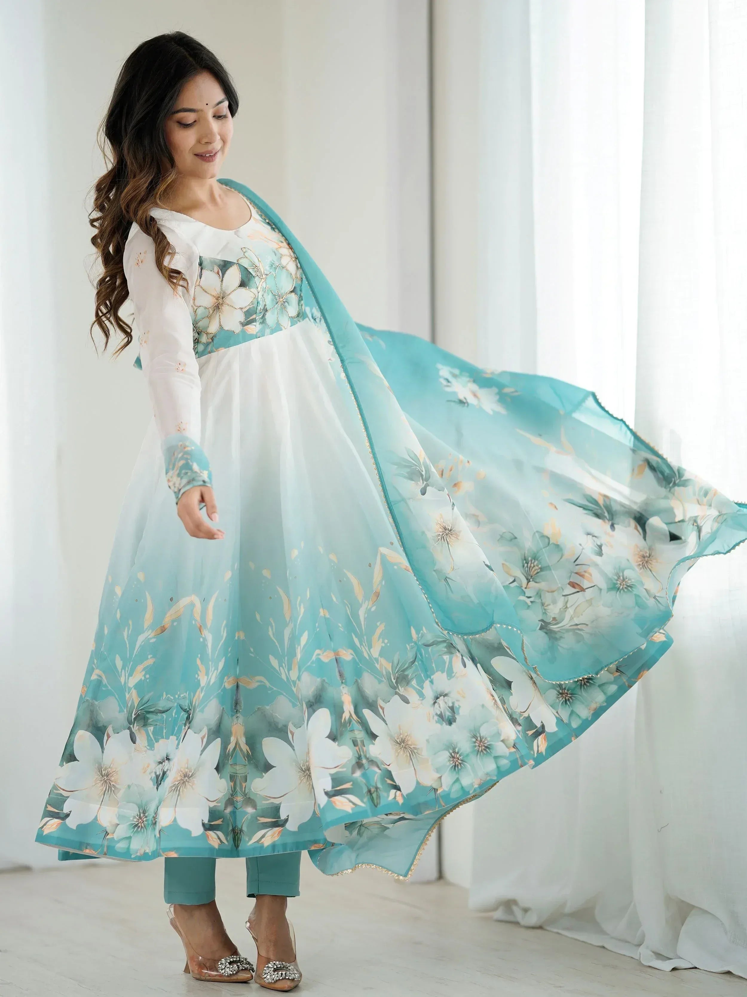 Woman in white and teal floral printed anarkali suit with matching dupatta, ethnic Indian wear