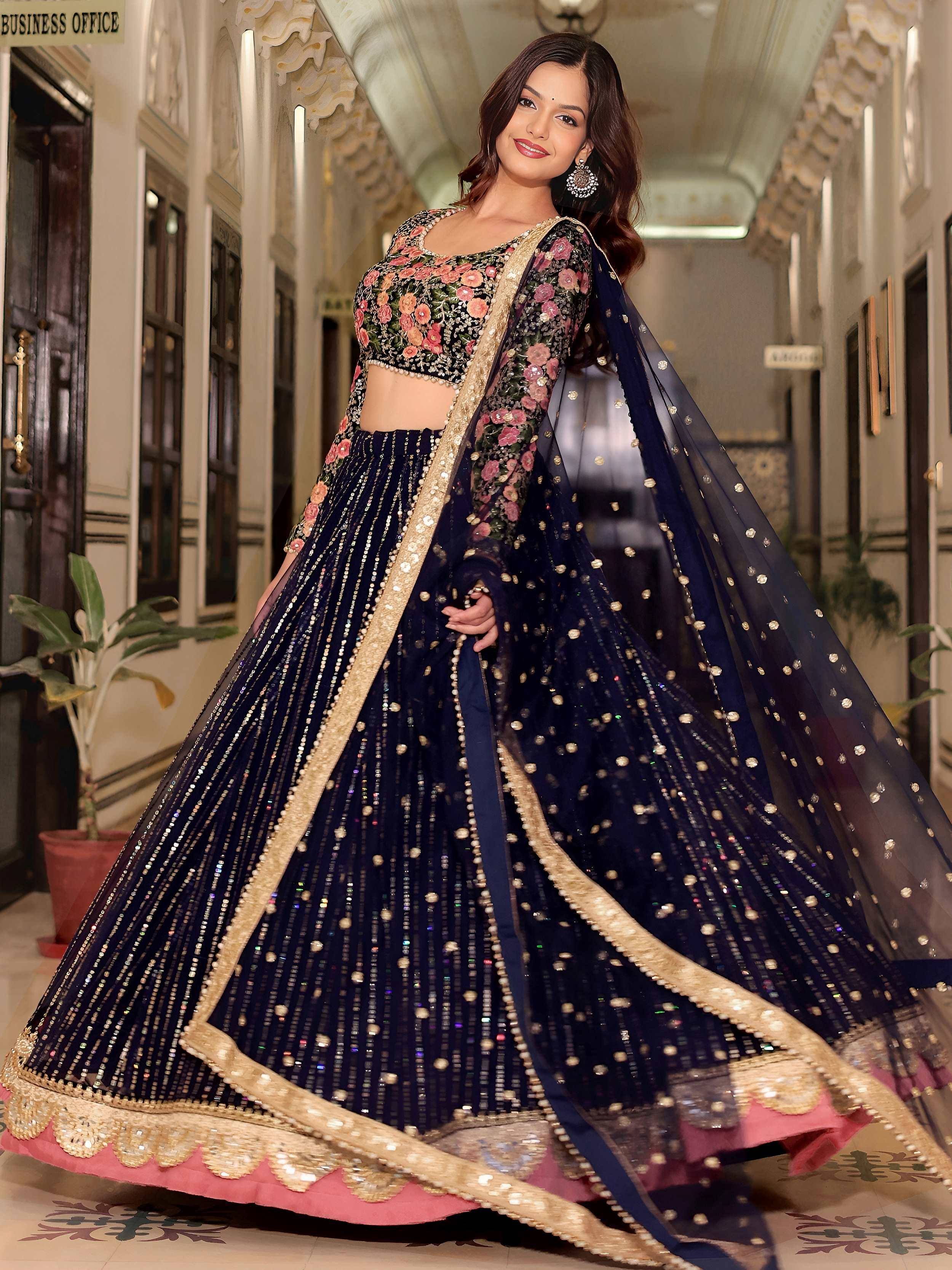 Navy blue designer lehenga choli with floral embroidery and gold sequins, perfect for weddings and parties.