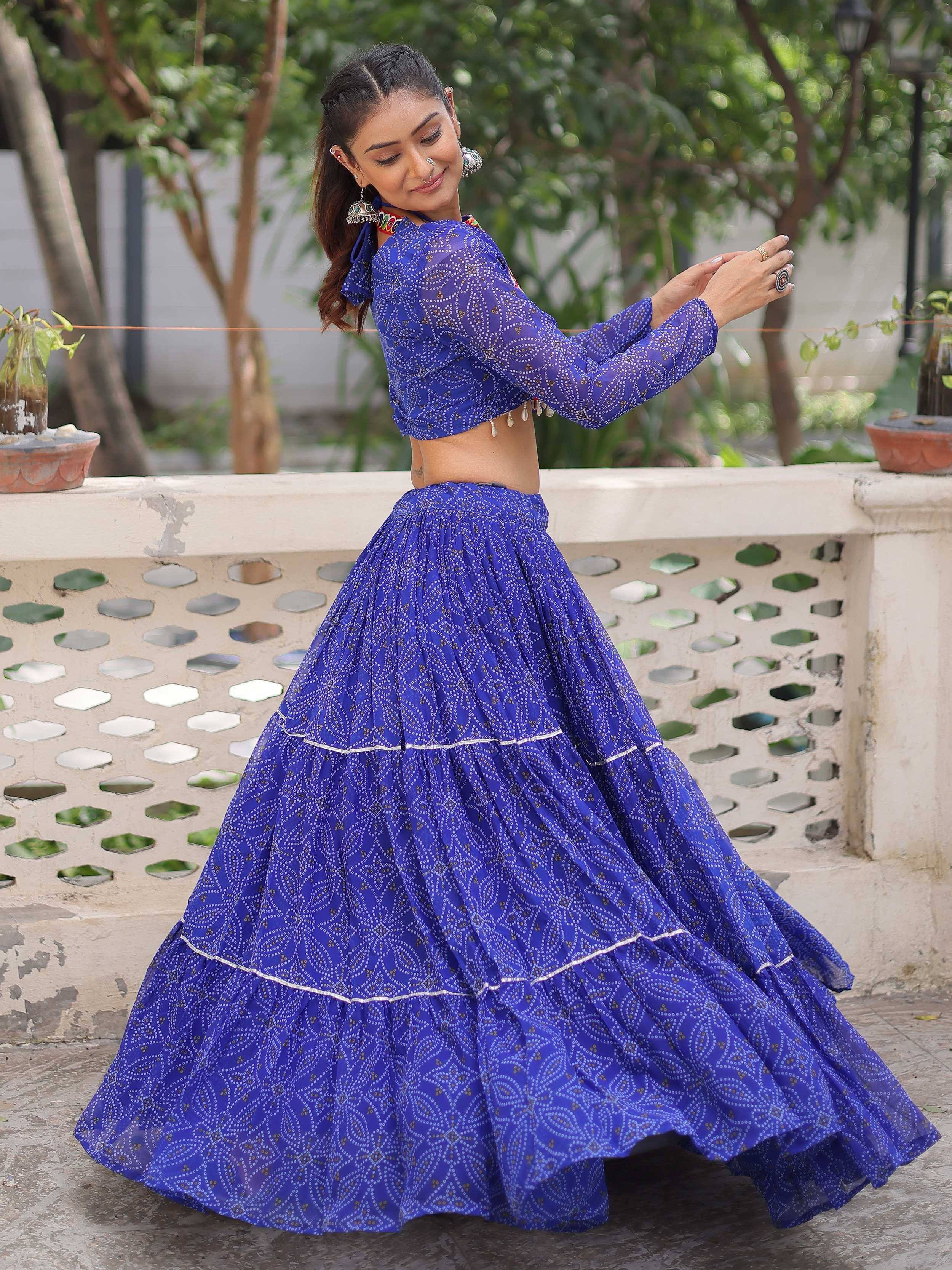 Woman in blue printed ethnic lehenga choli with tiered skirt, perfect for Indian festive occasions