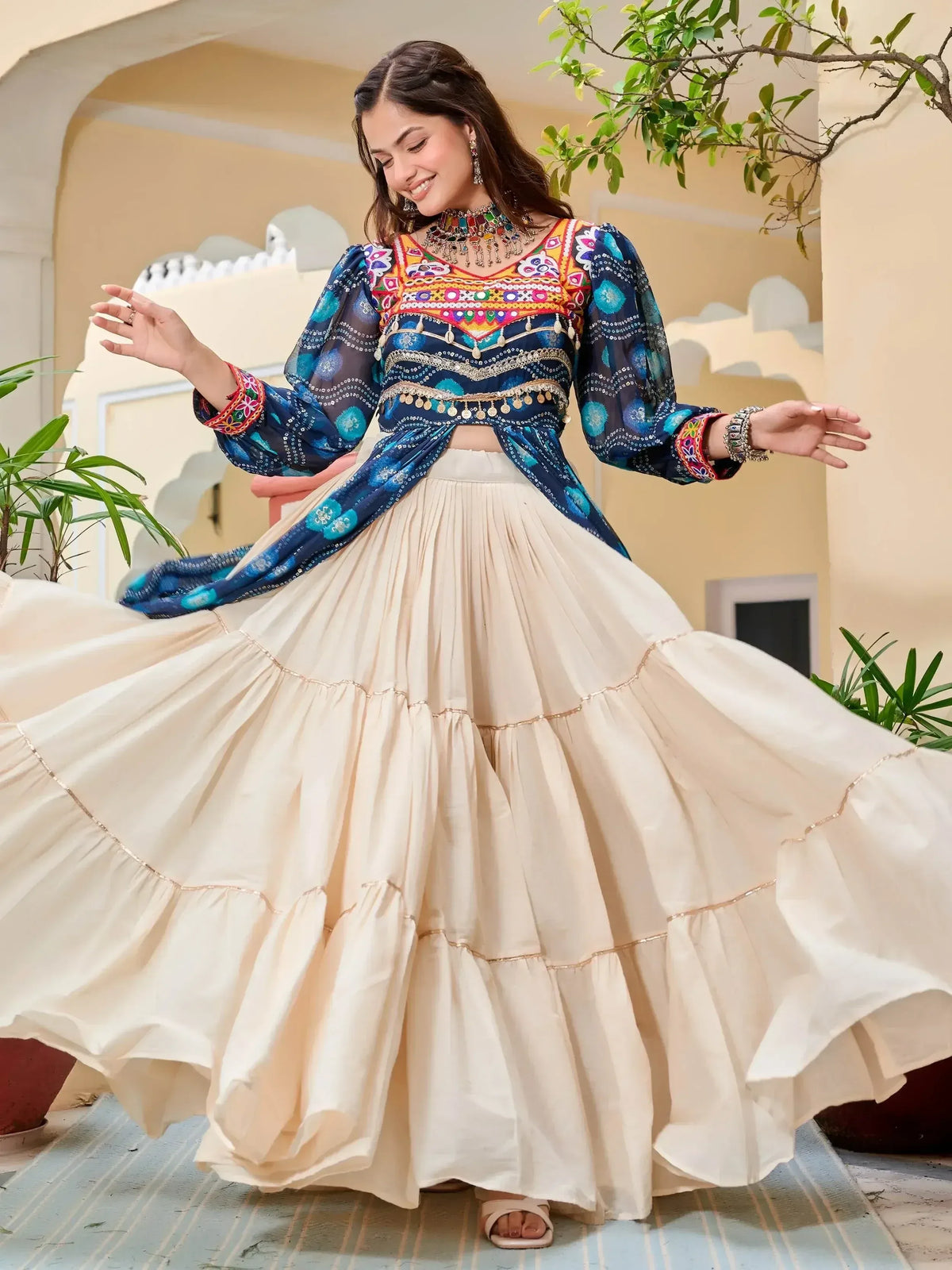 Woman in colorful embroidered blue top and cream tiered skirt, Indian ethnic wear