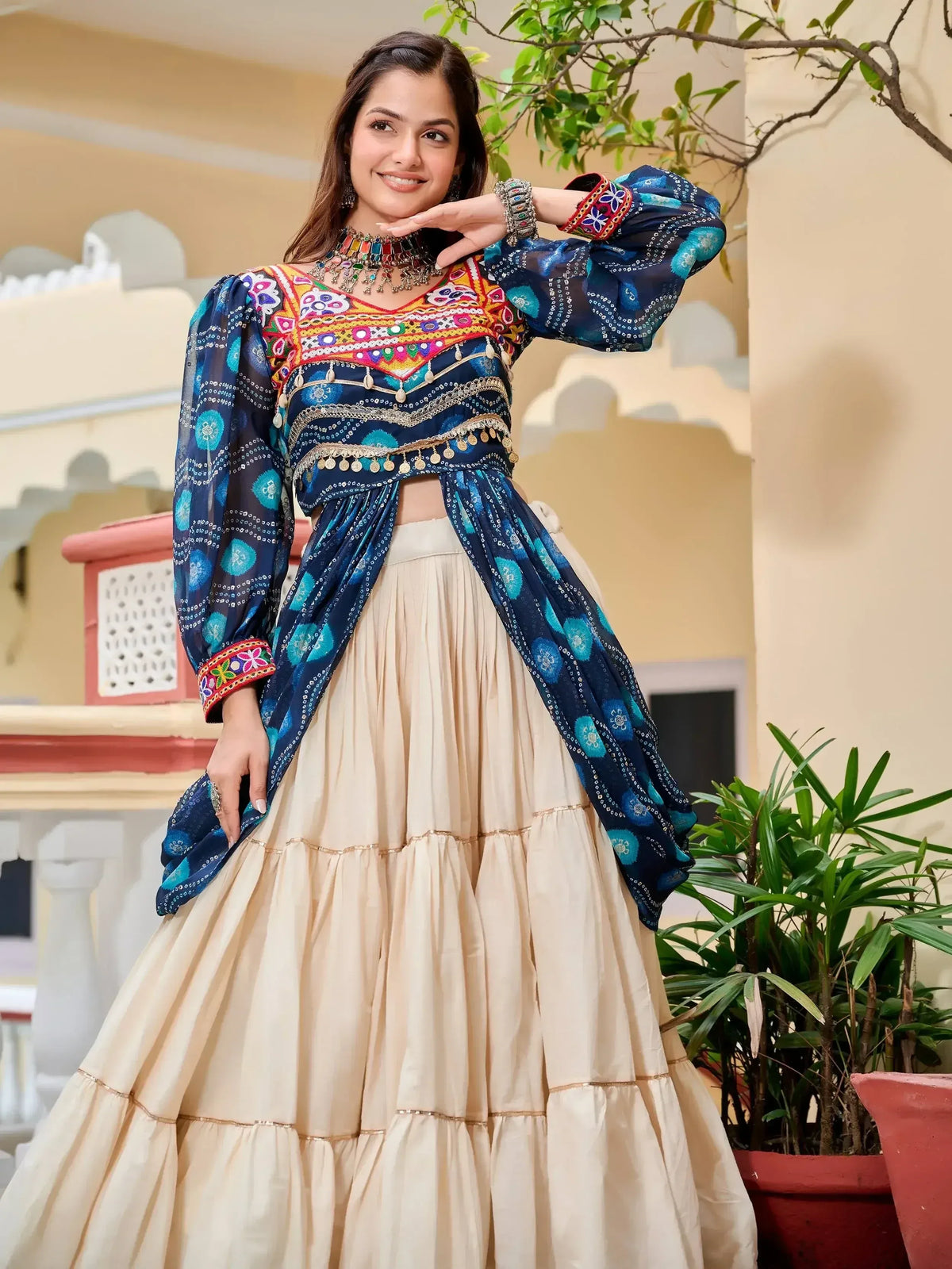 Woman in vibrant blue embroidered crop top with beige tiered skirt, Indian ethnic wear