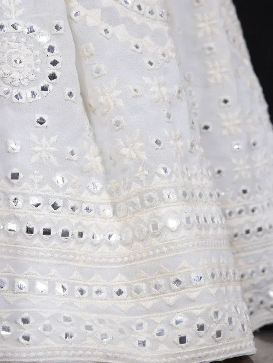 White ethnic gown with mirror work and floral embroidery, perfect for Indian festive wear.