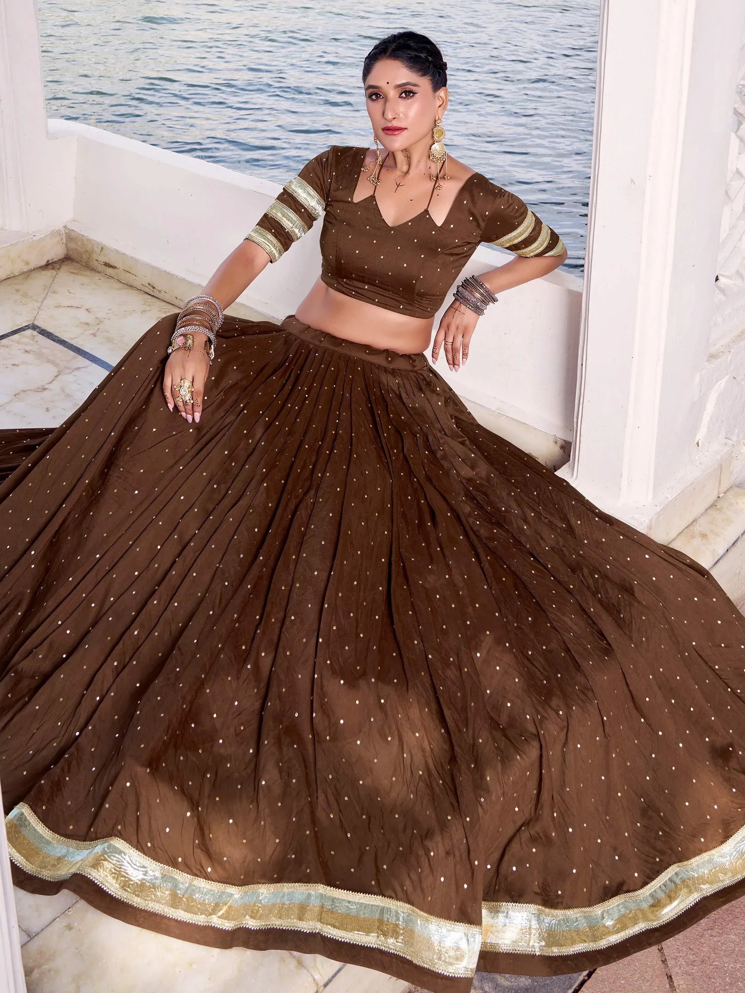 Brown designer lehenga choli with gold embellishments, perfect for Indian ethnic wear occasions.