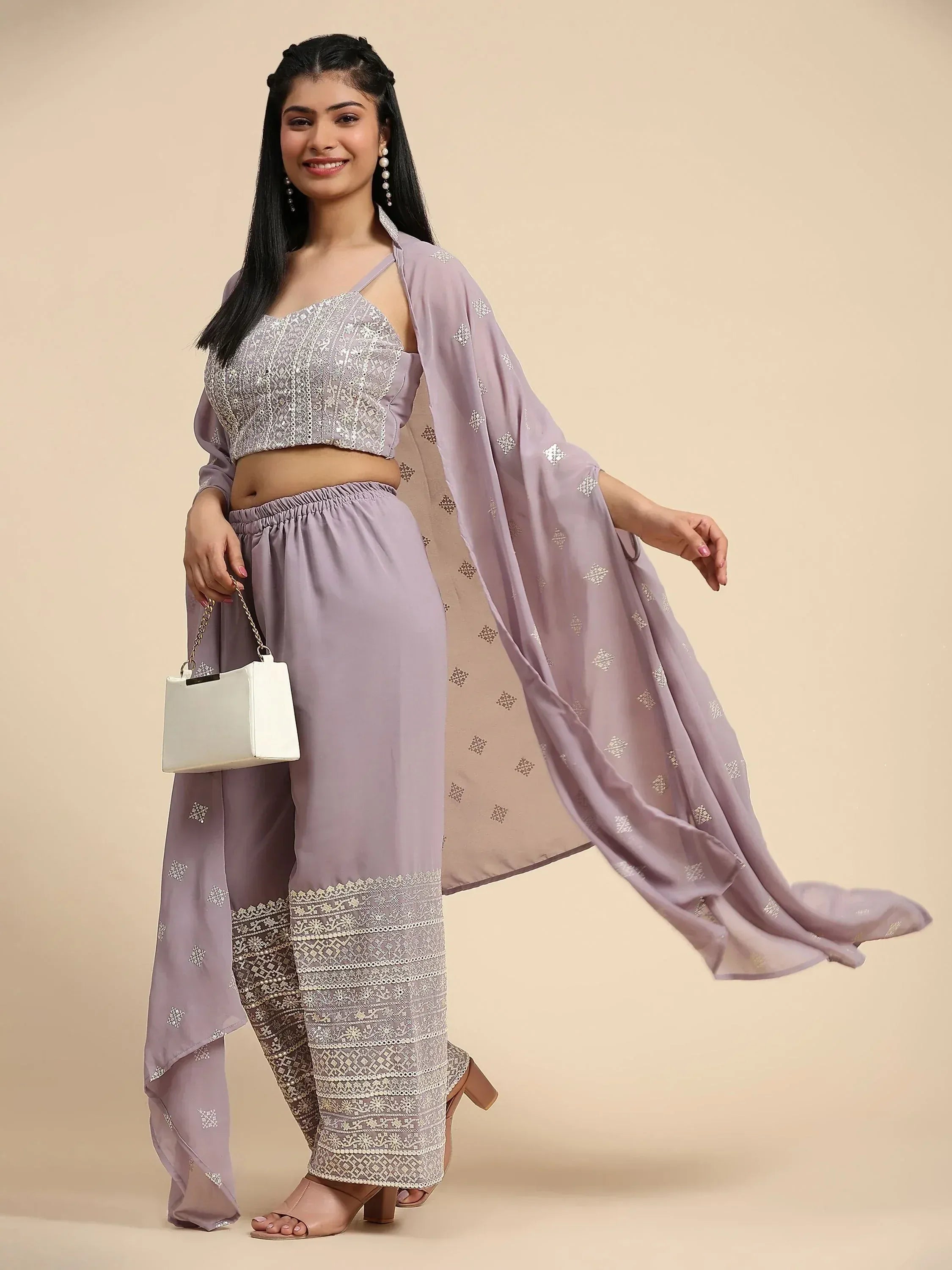 Woman wearing lavender embroidered ethnic co-ord set with dupatta, holding white handbag