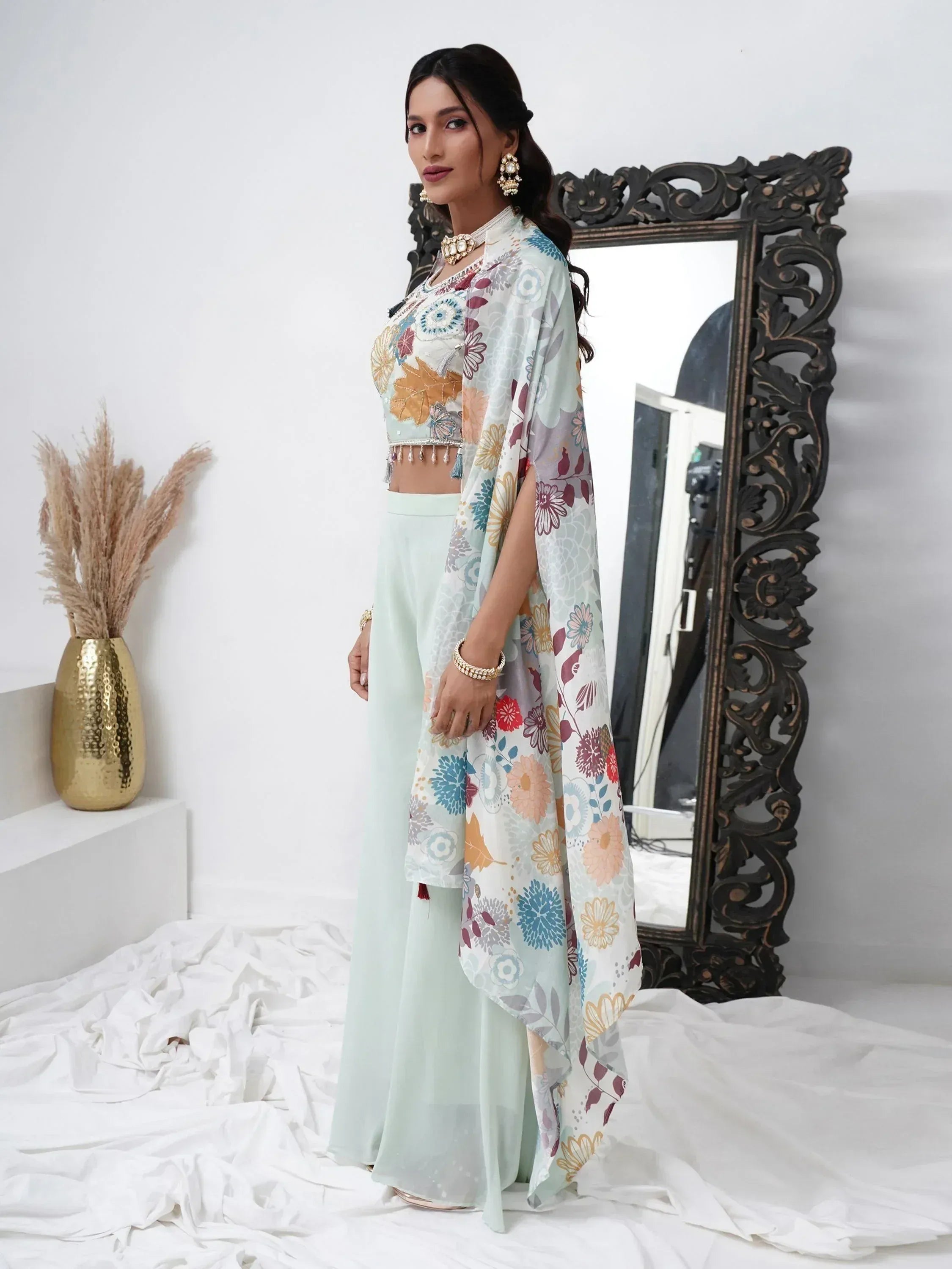 Woman in pastel floral lehenga choli with dupatta, standing in modern ethnic wear setting