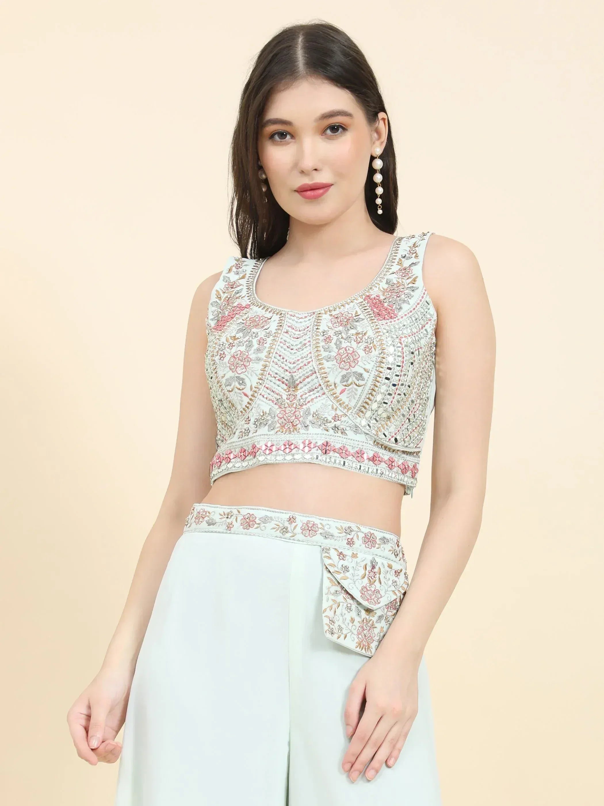 Woman wearing pastel embroidered crop top and high-waisted palazzo pants, ethnic fashion