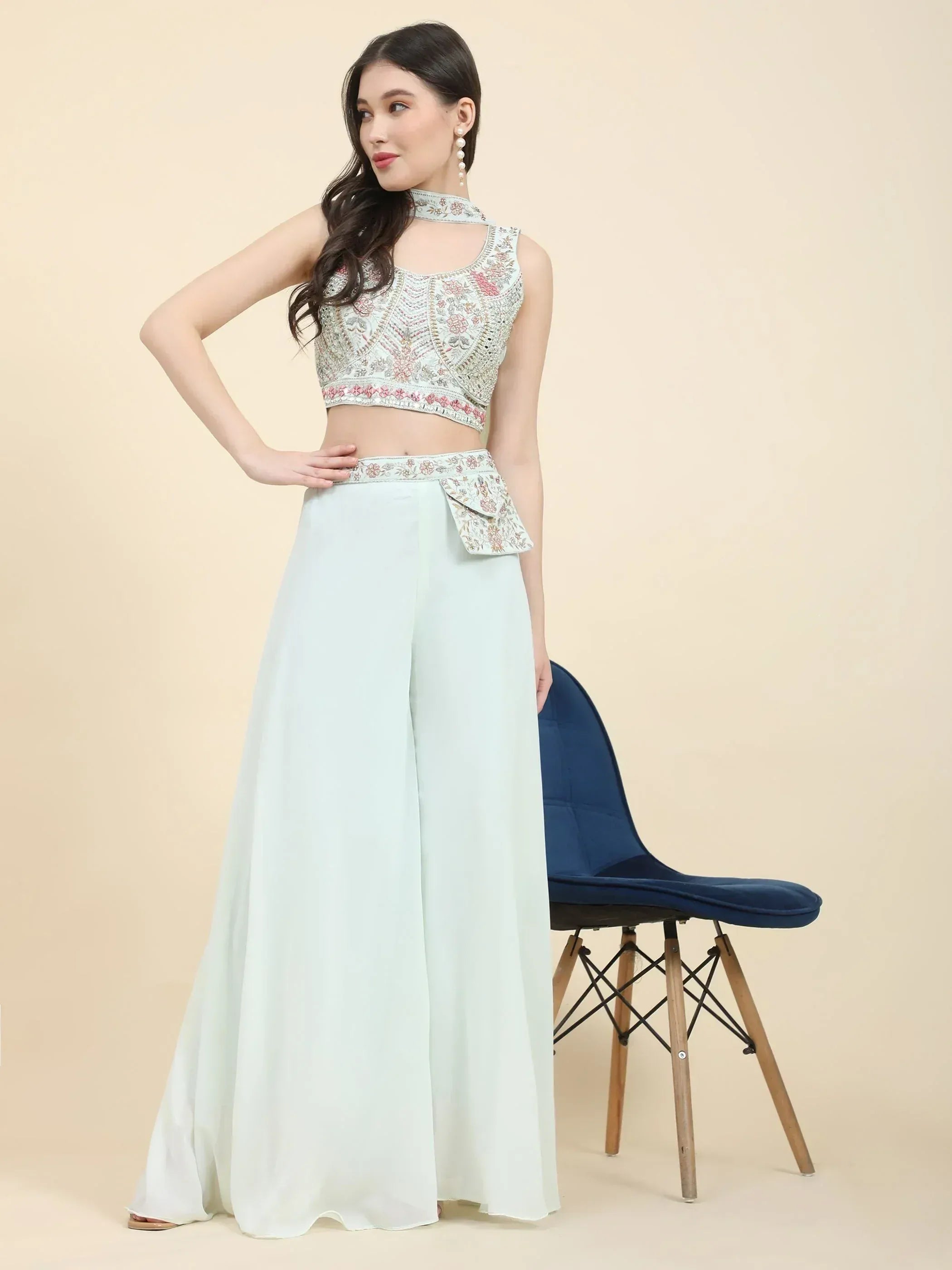 Woman in pastel embroidered Indian crop top and palazzo set, posing indoors