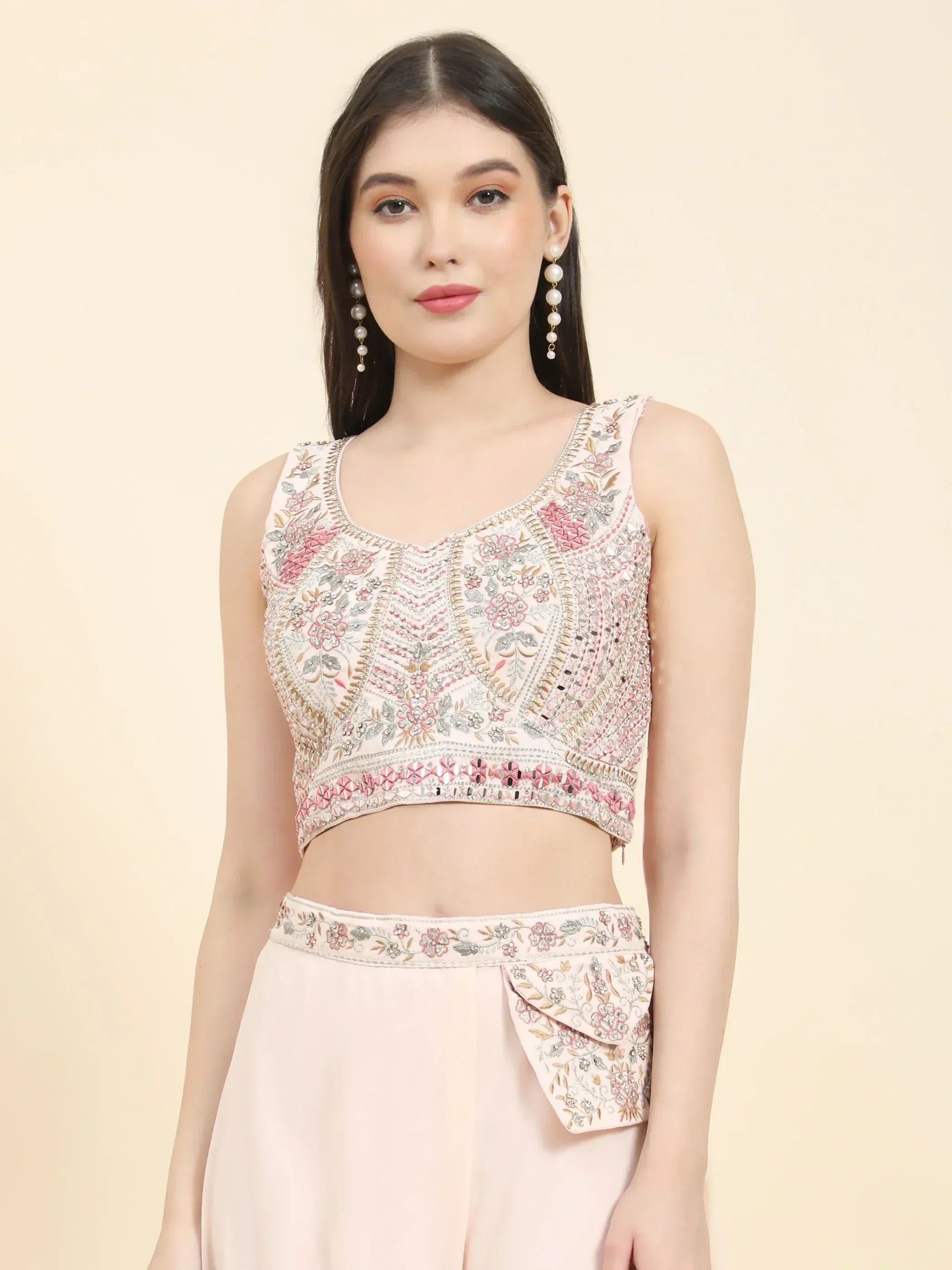 Woman wearing pastel floral embroidered crop top and matching lehenga skirt