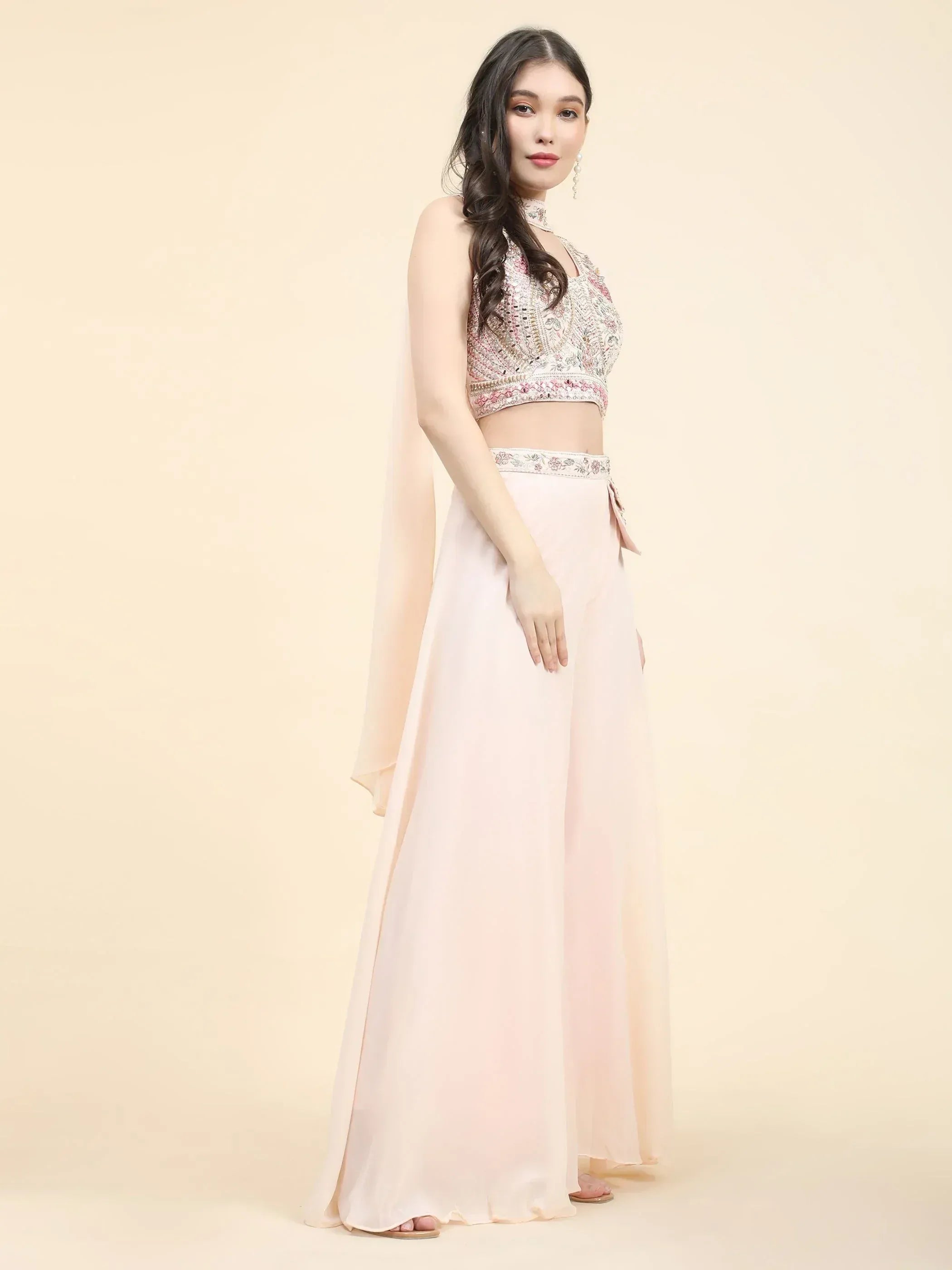 Woman in pastel pink embroidered lehenga choli with sheer dupatta, ethnic wear fashion