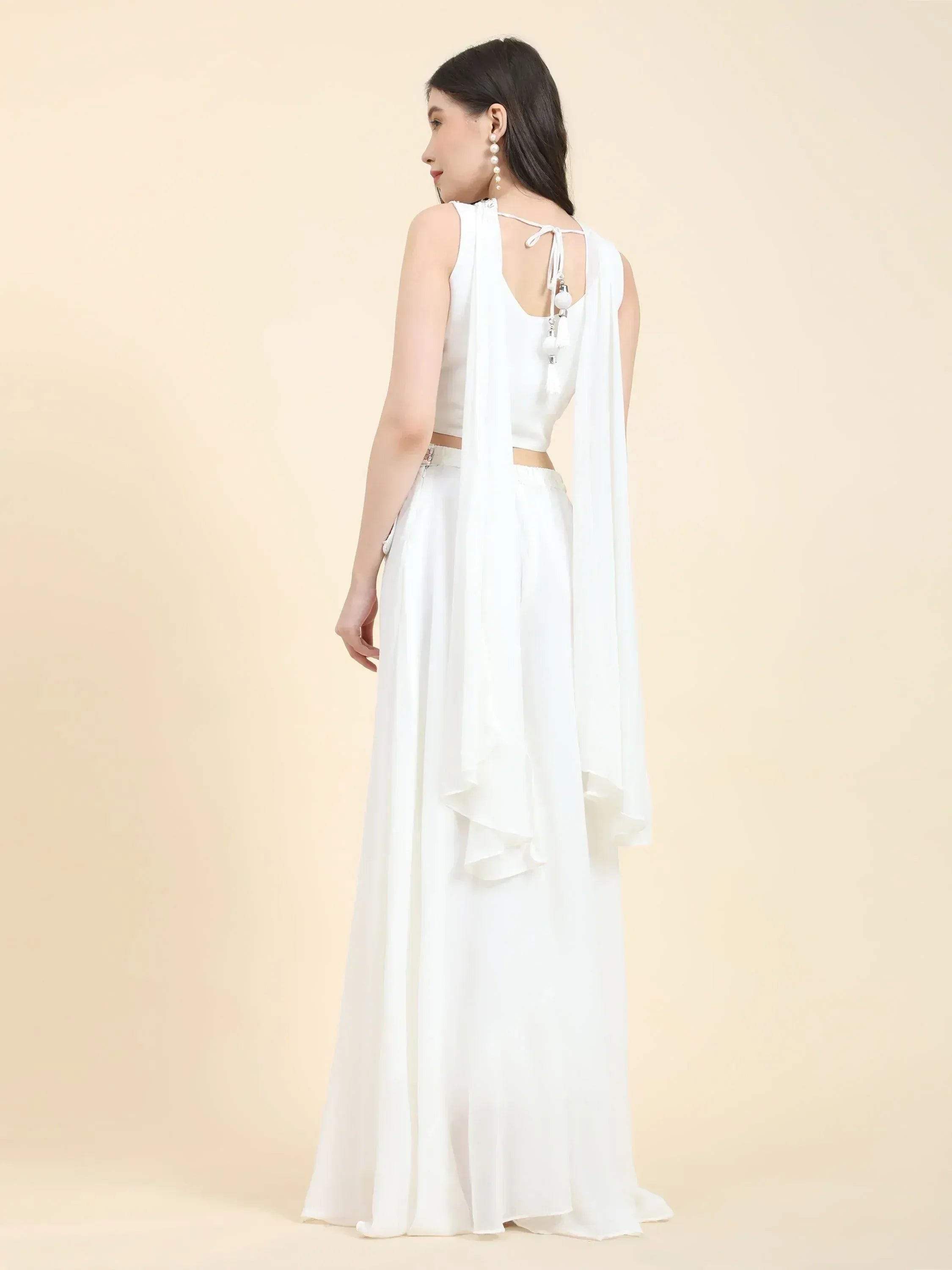 Woman wearing a stylish white lehenga choli set with flowing dupatta, back view