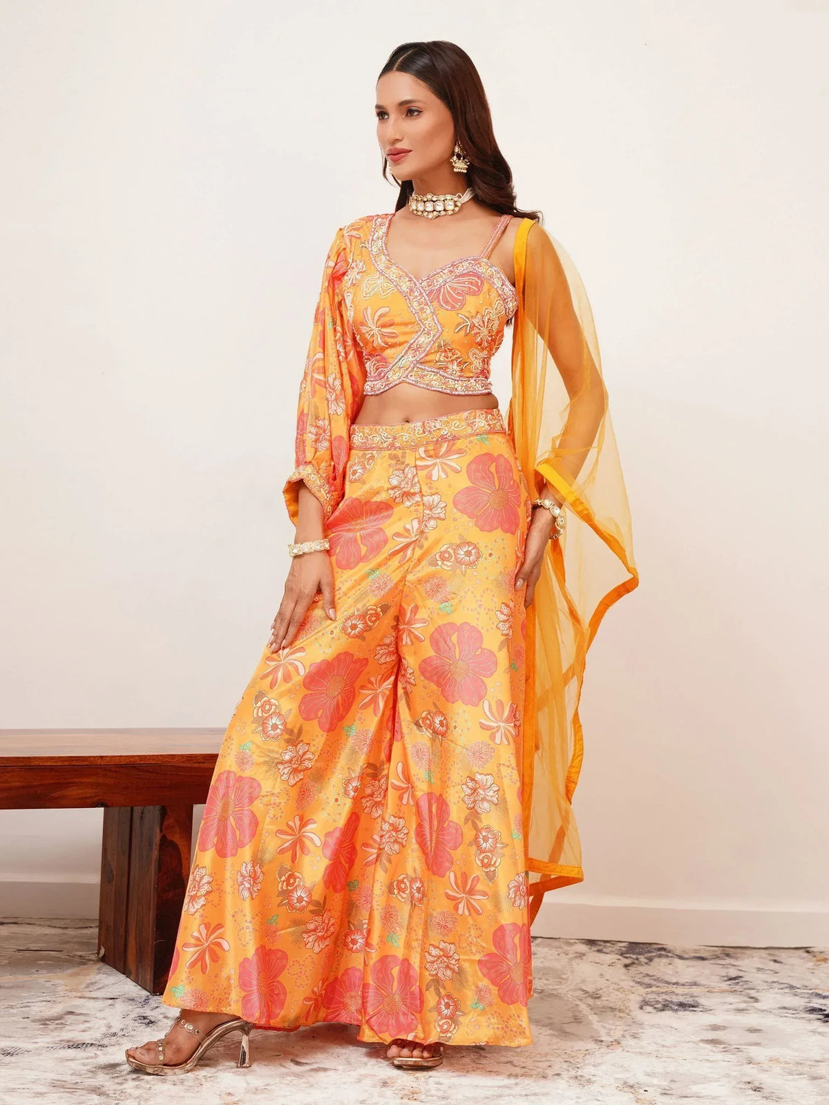 Vibrant orange floral print palazzo set with embroidered crop top and sheer dupatta, perfect for ethnic occasions.