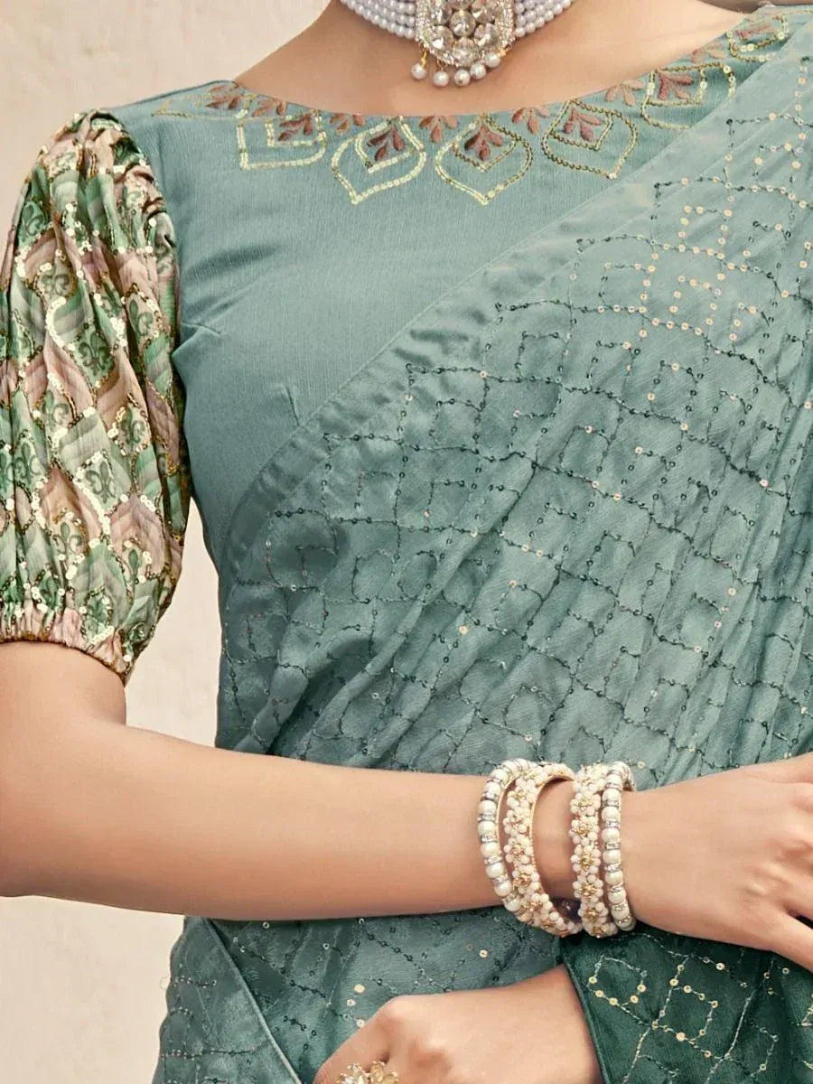 Elegant sage green saree with sequin embroidery, puff sleeves, and pearl jewelry for Indian ethnic wear