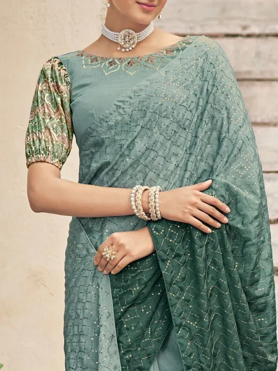 Elegant green saree with embroidered blouse and pearl jewelry, perfect for Indian ethnic occasions.