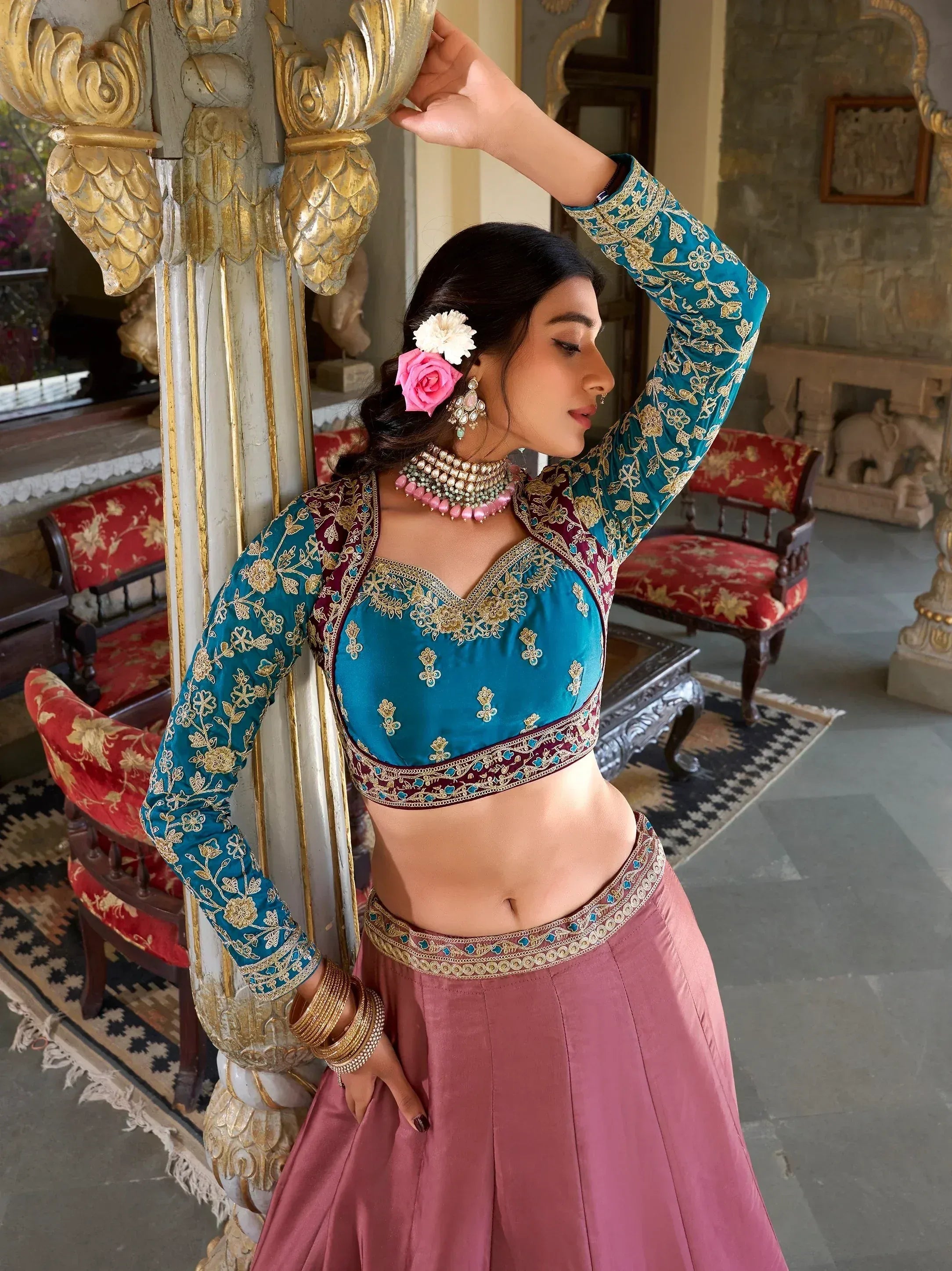 Teal embroidered blouse with pink lehenga, gold detailing, floral hair accessories, traditional Indian ethnic wear
