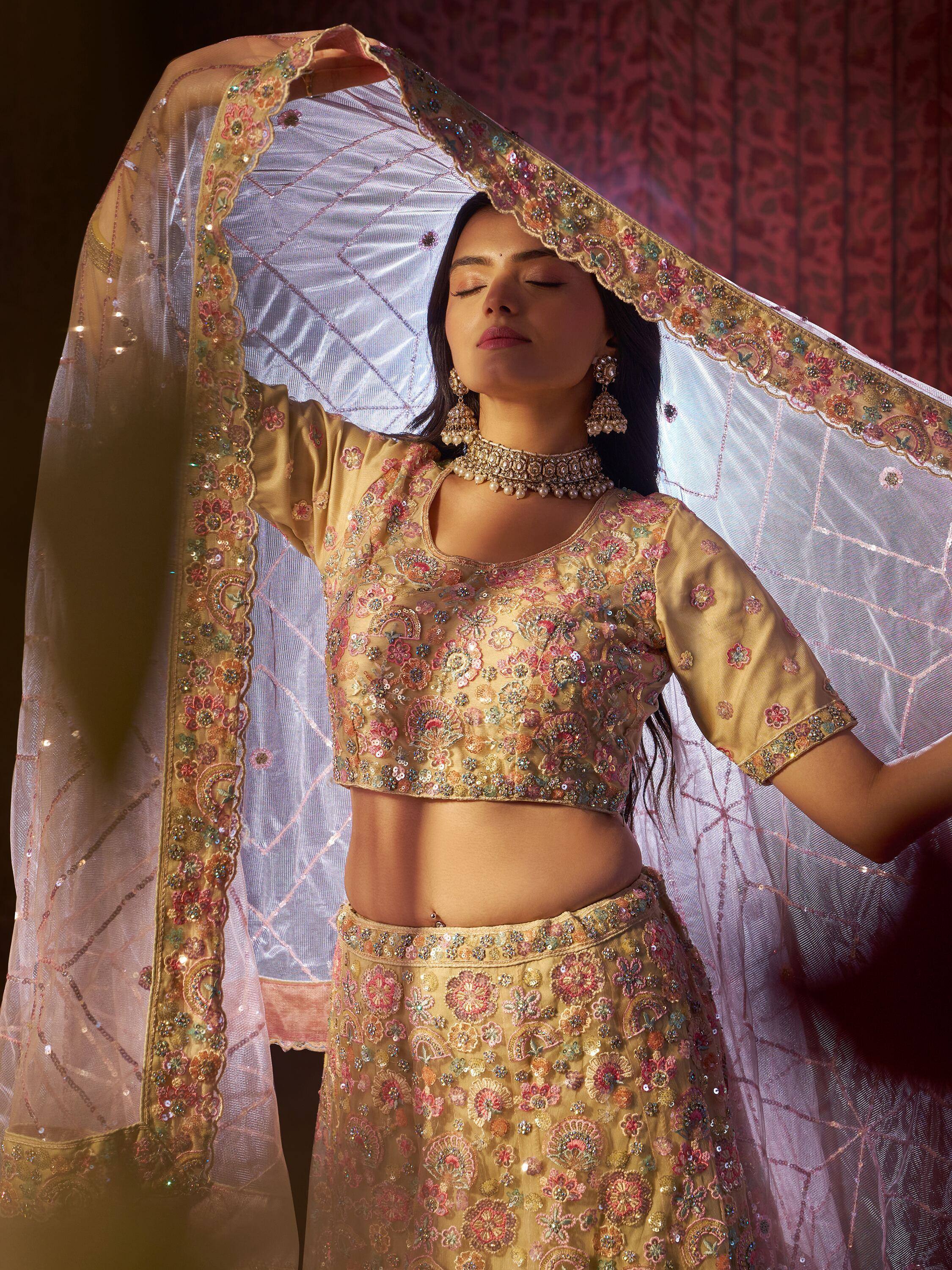 Elegant gold lehenga choli with floral embroidery and sheer dupatta, perfect for Indian ethnic wear occasions.