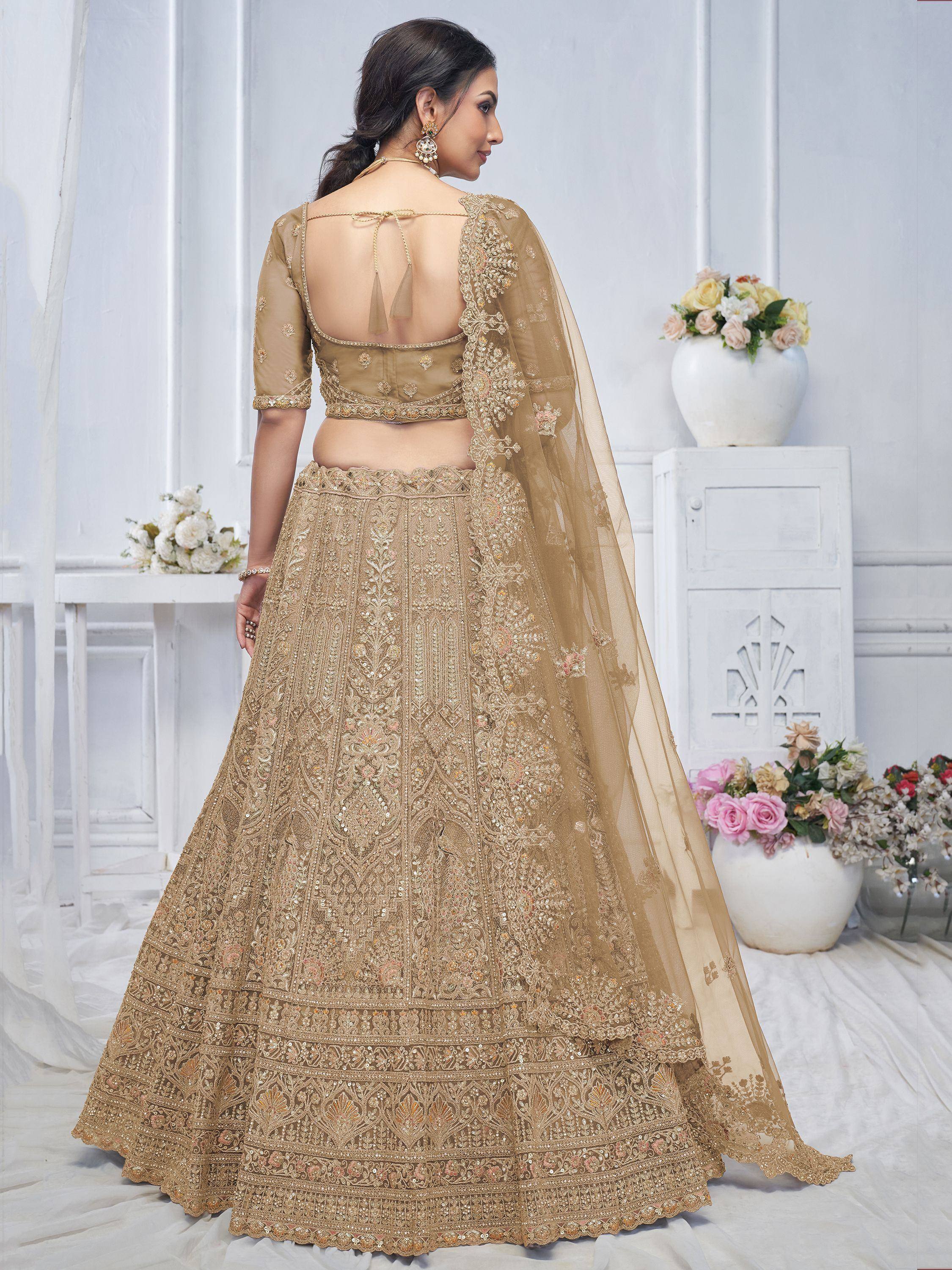 Elegant gold lehenga choli with intricate embroidery and sheer dupatta, perfect for Indian weddings and festive occasions.