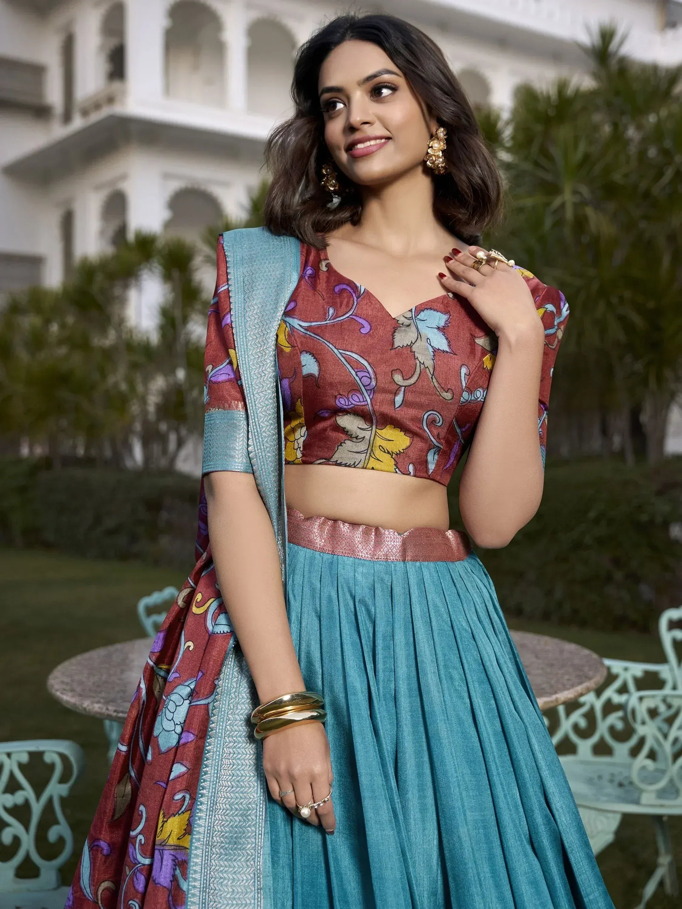 Woman in vibrant printed lehenga choli with blue skirt and floral top, perfect for Indian ethnic occasions