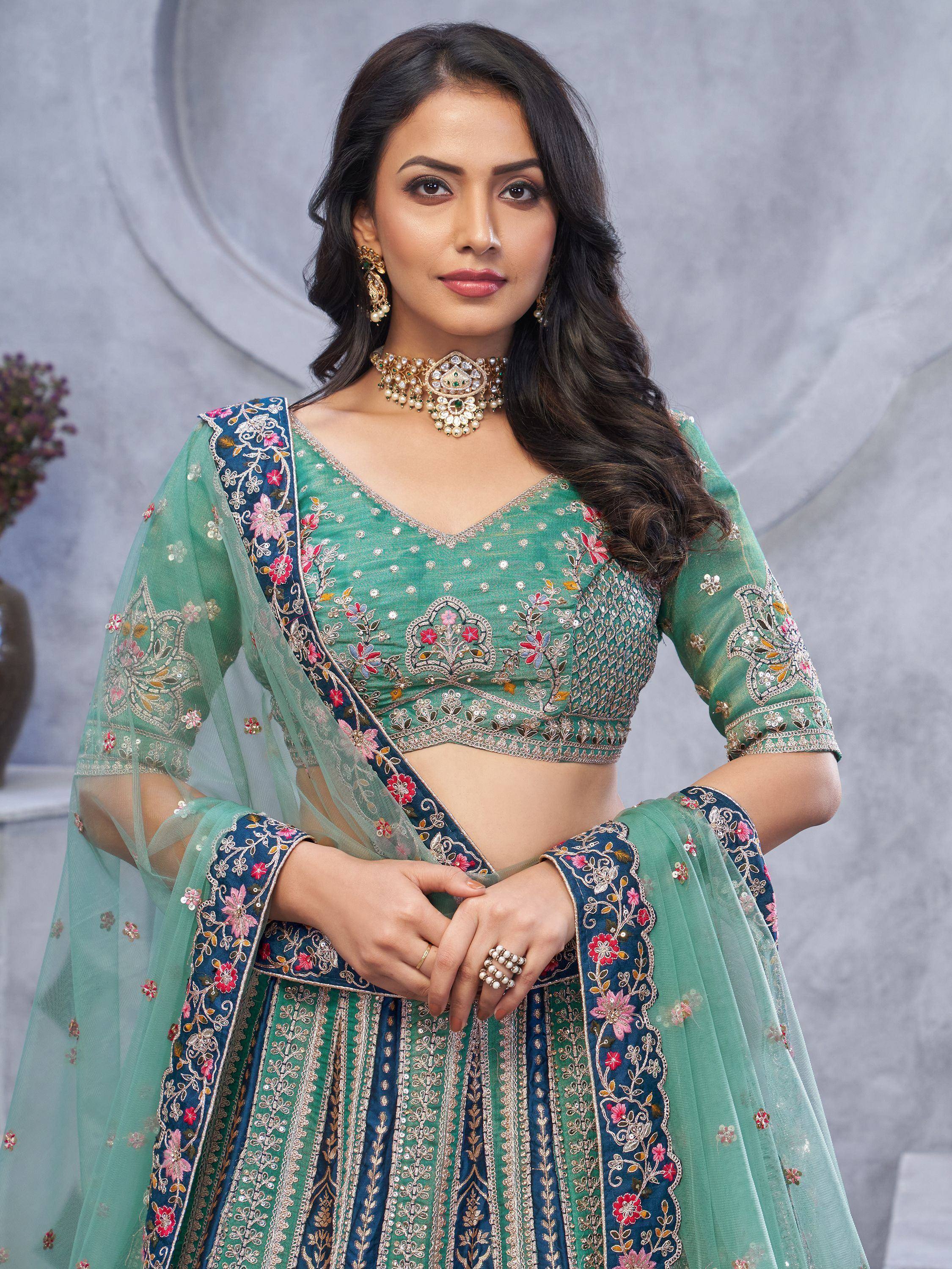 Green and blue embroidered lehenga choli with floral detailing and matching dupatta, perfect for Indian ethnic occasions.
