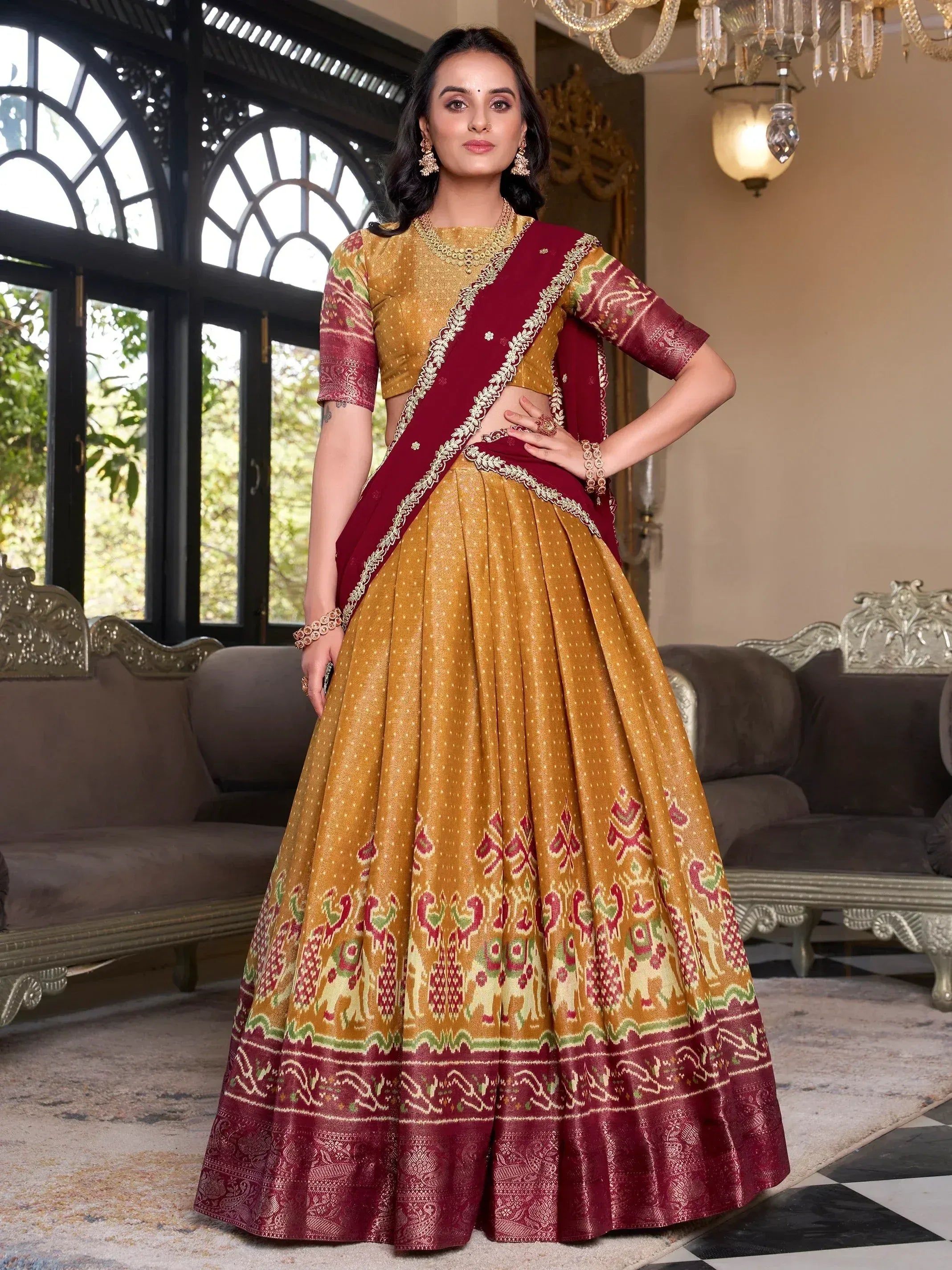 Elegant maroon and gold designer lehenga choli with intricate embroidery and traditional patterns