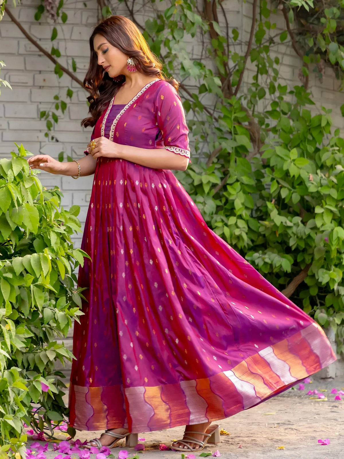 Woman in vibrant purple ethnic gown with gold motifs and border, perfect for Indian occasions