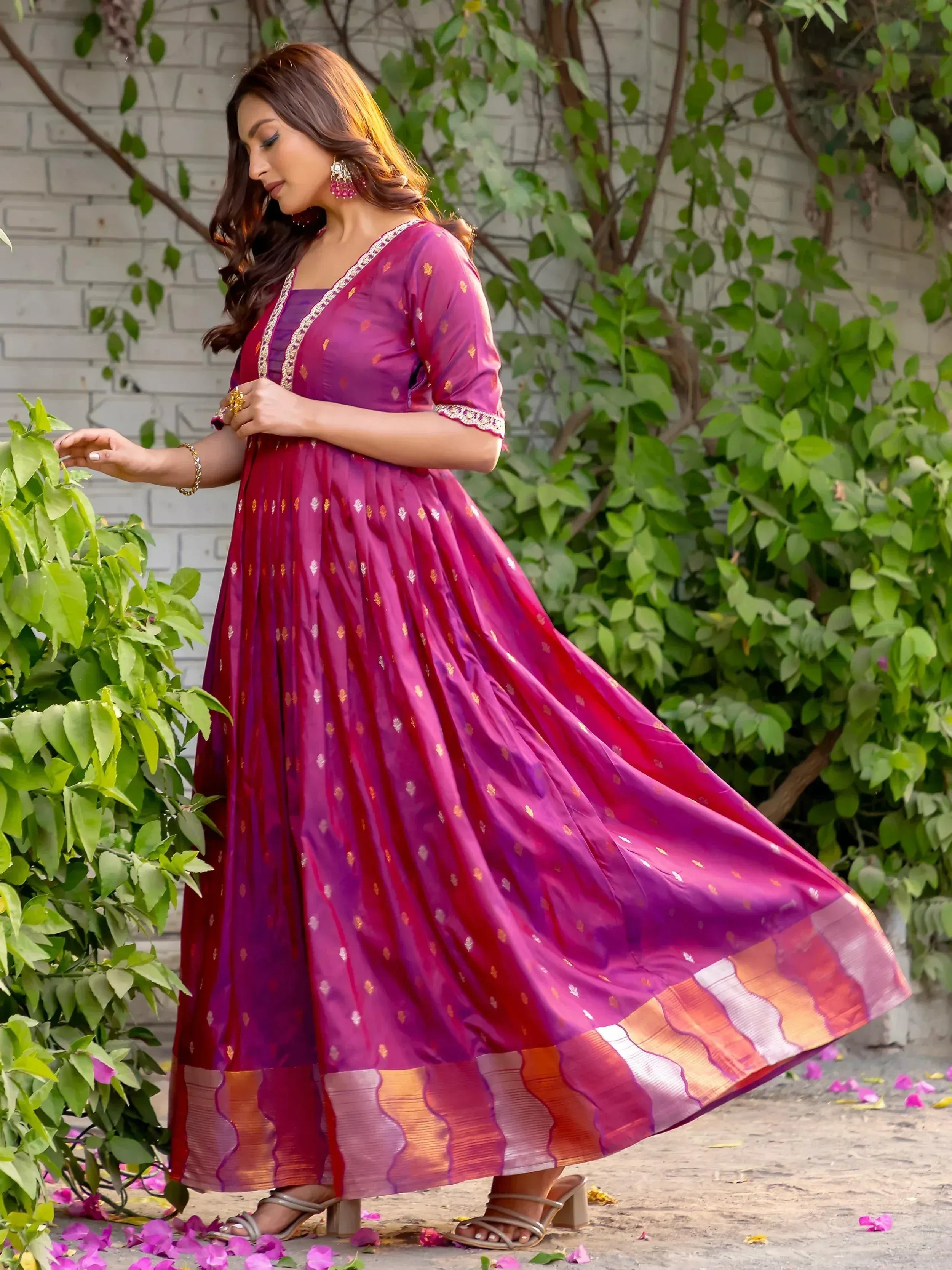 Elegant purple ethnic gown with golden motifs and colorful border, perfect for festive occasions