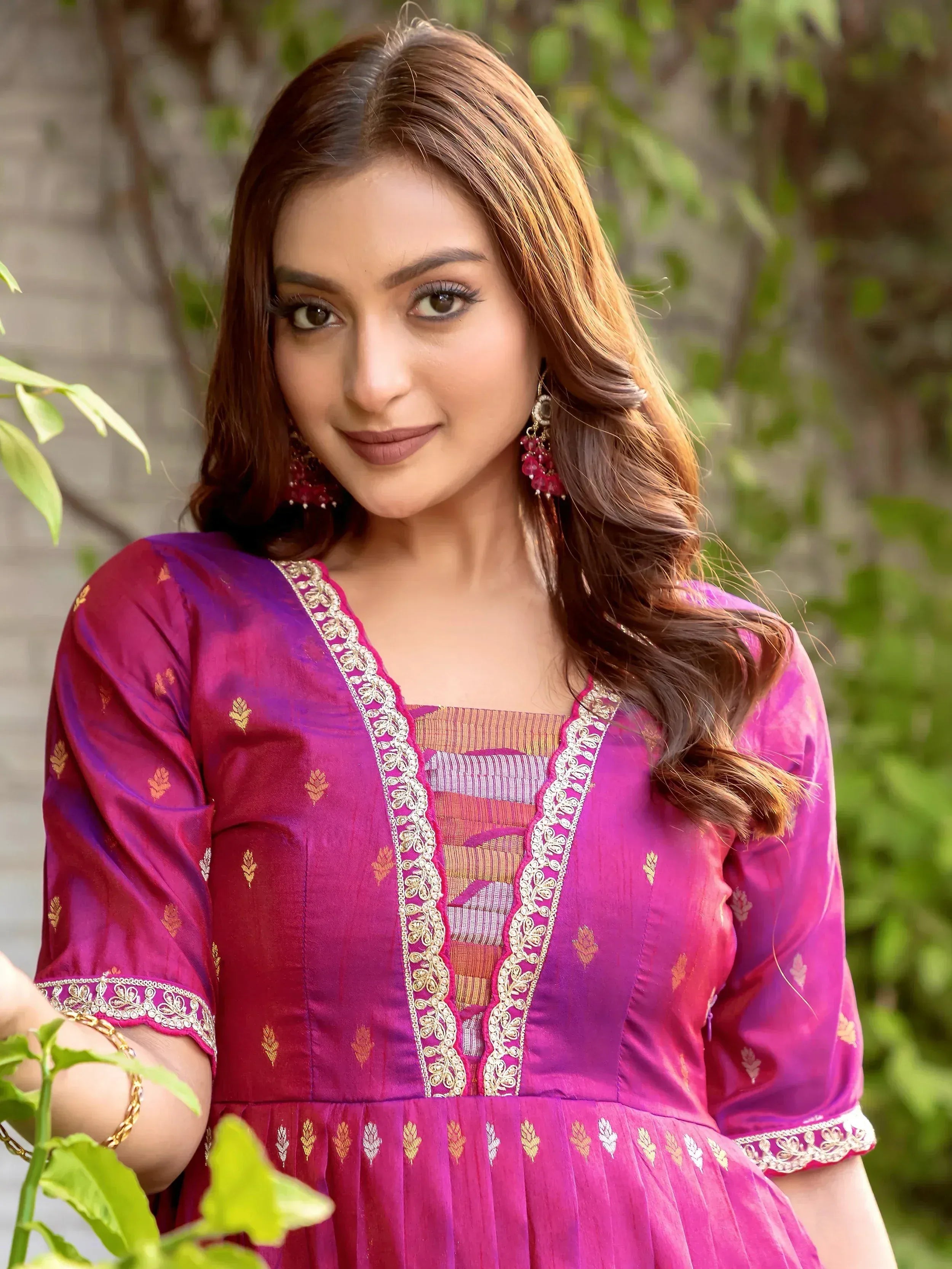 Woman in vibrant pink ethnic kurti with gold embroidery, perfect for Indian occasions and festive wear.