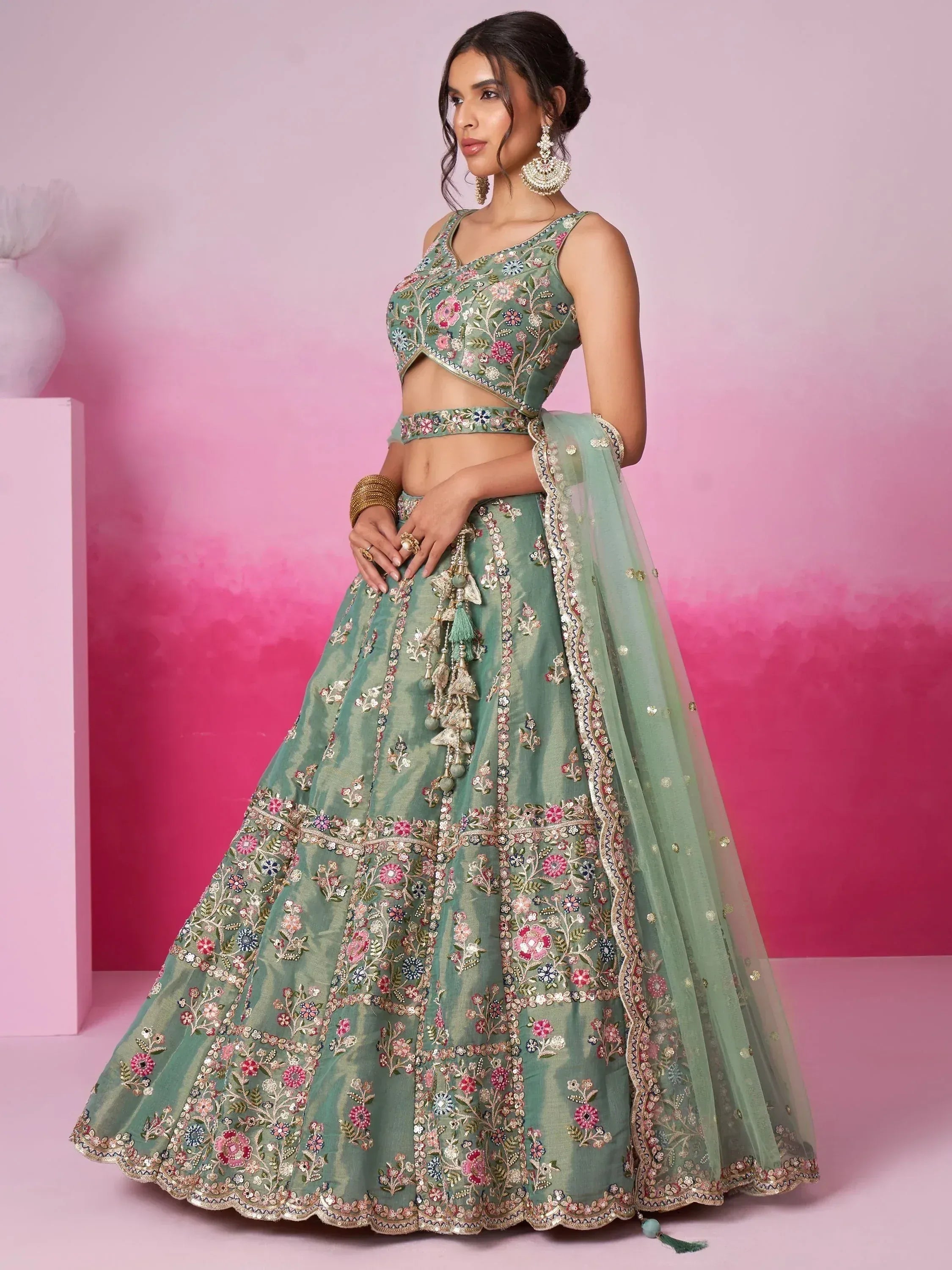 Mint green embroidered lehenga choli with floral motifs and tassels, perfect for Indian weddings or festive occasions.