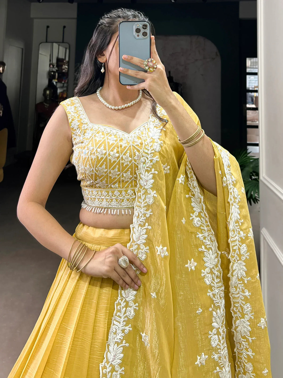 Yellow designer lehenga choli with white floral embroidery, perfect for Indian ethnic wear occasions.