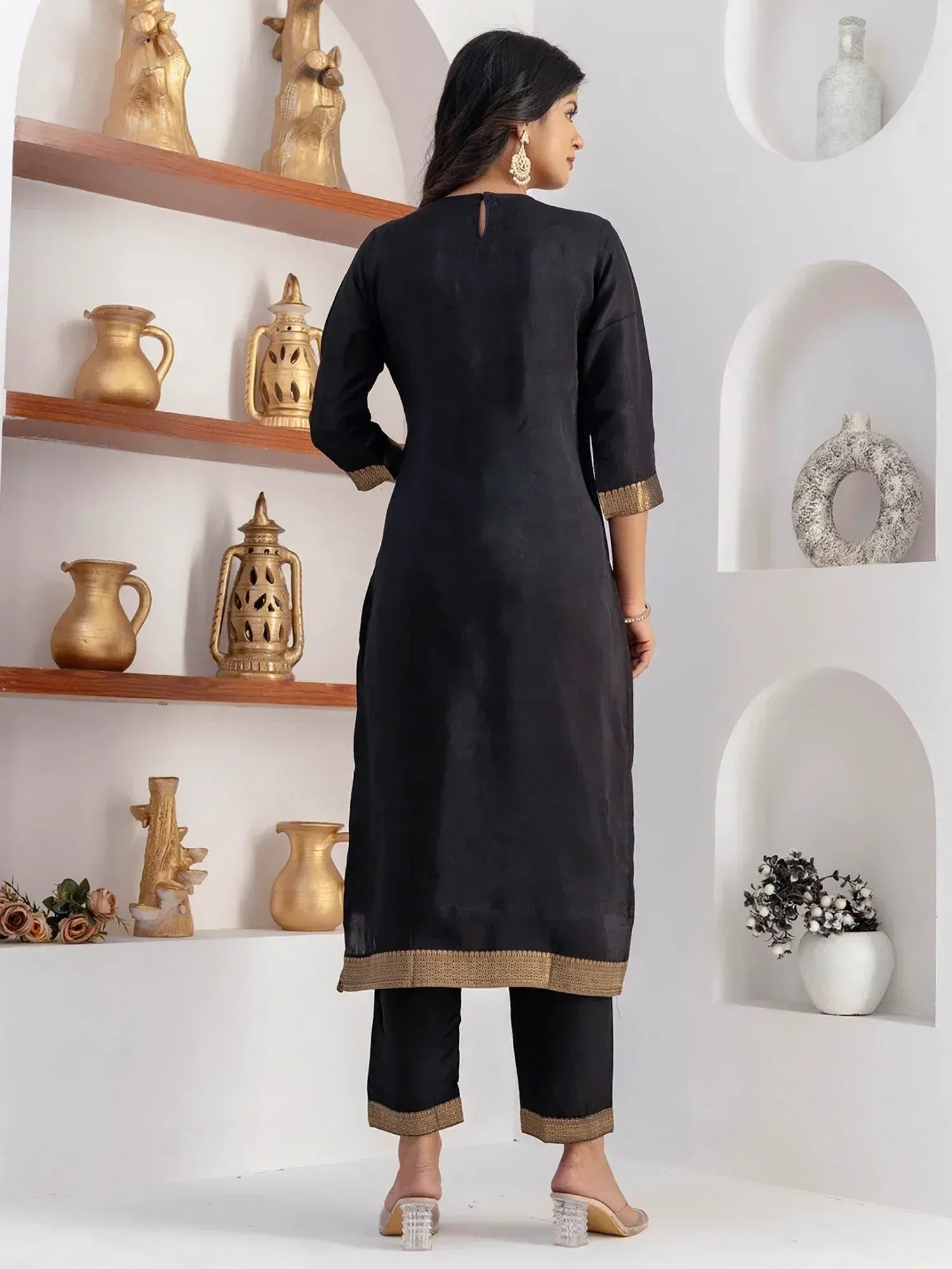 Black ethnic kurta with gold trim, paired with matching pants, styled for Indian wear