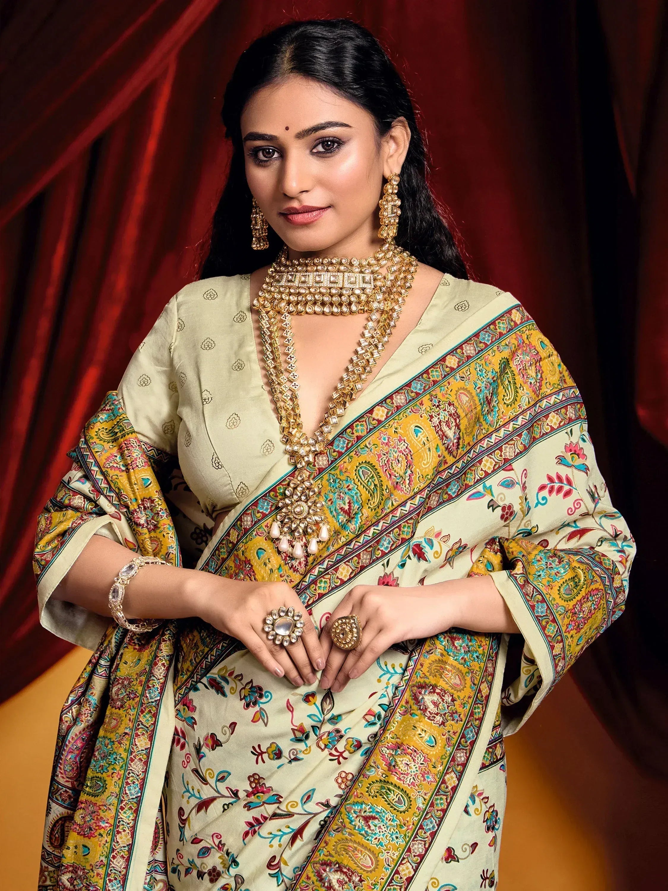 Woman in elegant Indian saree with floral paisley print, gold jewelry, and traditional ethnic wear styling