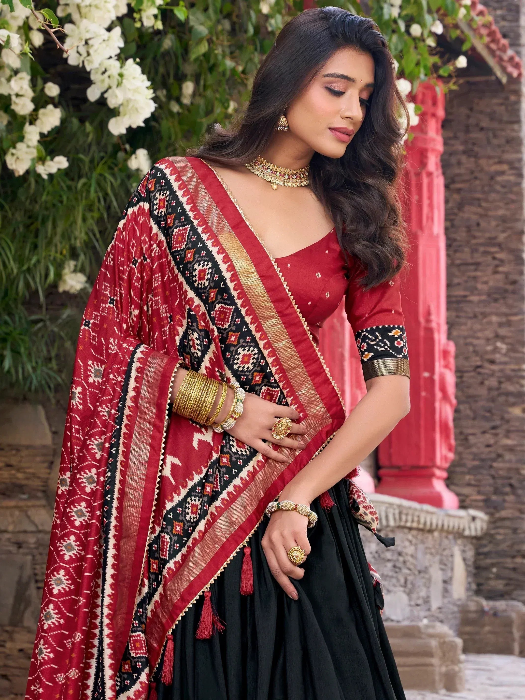 Red and black ethnic lehenga choli with geometric print dupatta, perfect for Indian weddings and festive occasions.