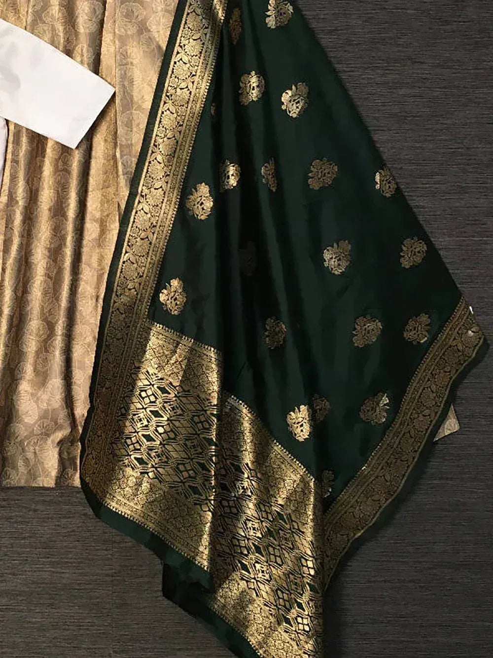 Emerald green saree with gold floral embroidery and intricate border, paired with golden blouse fabric