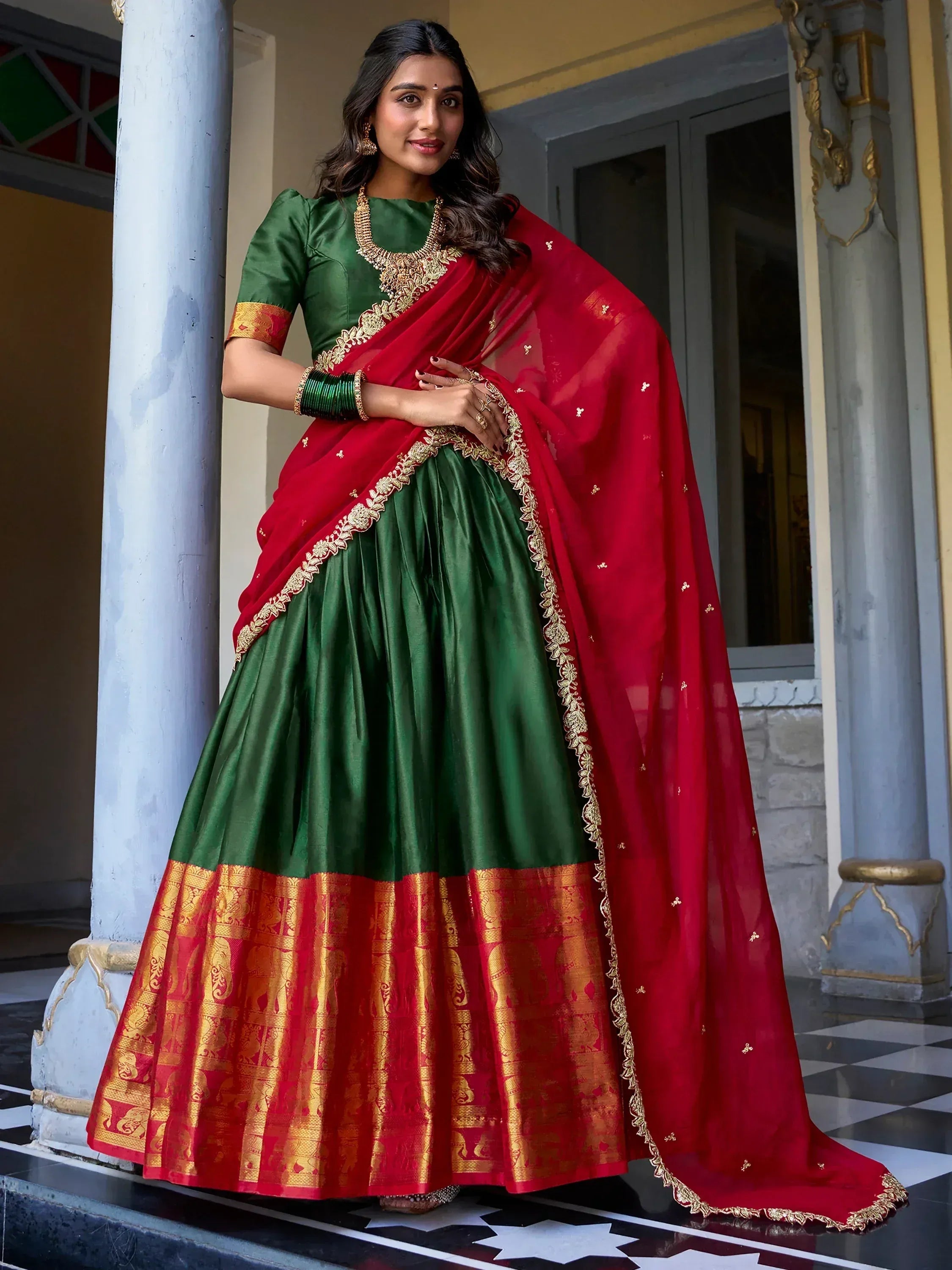 Green and red Indian lehenga choli with gold embroidery, perfect for festive occasions and weddings.