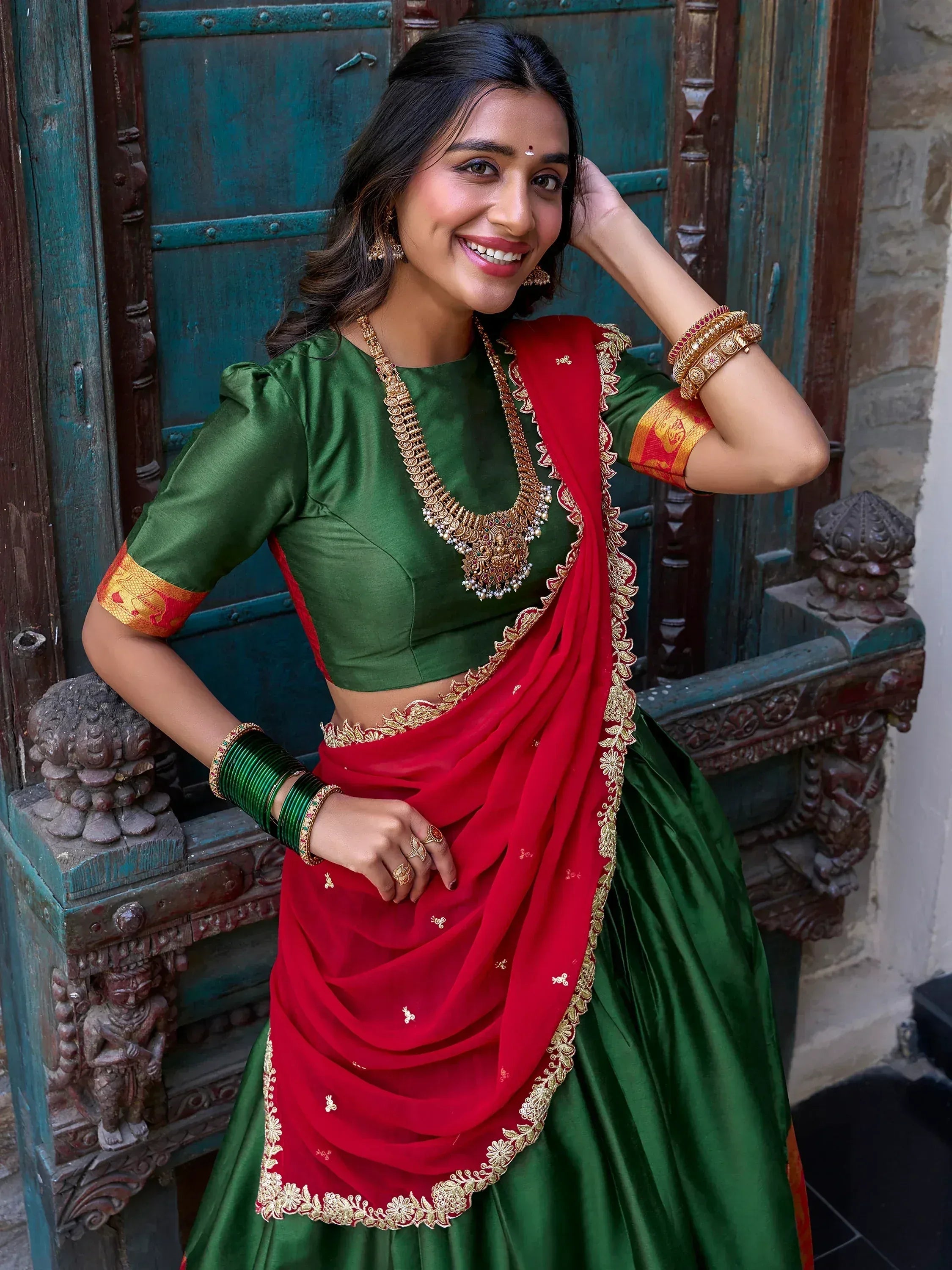 Green and red Indian lehenga choli with gold embroidery, perfect for weddings and festivals