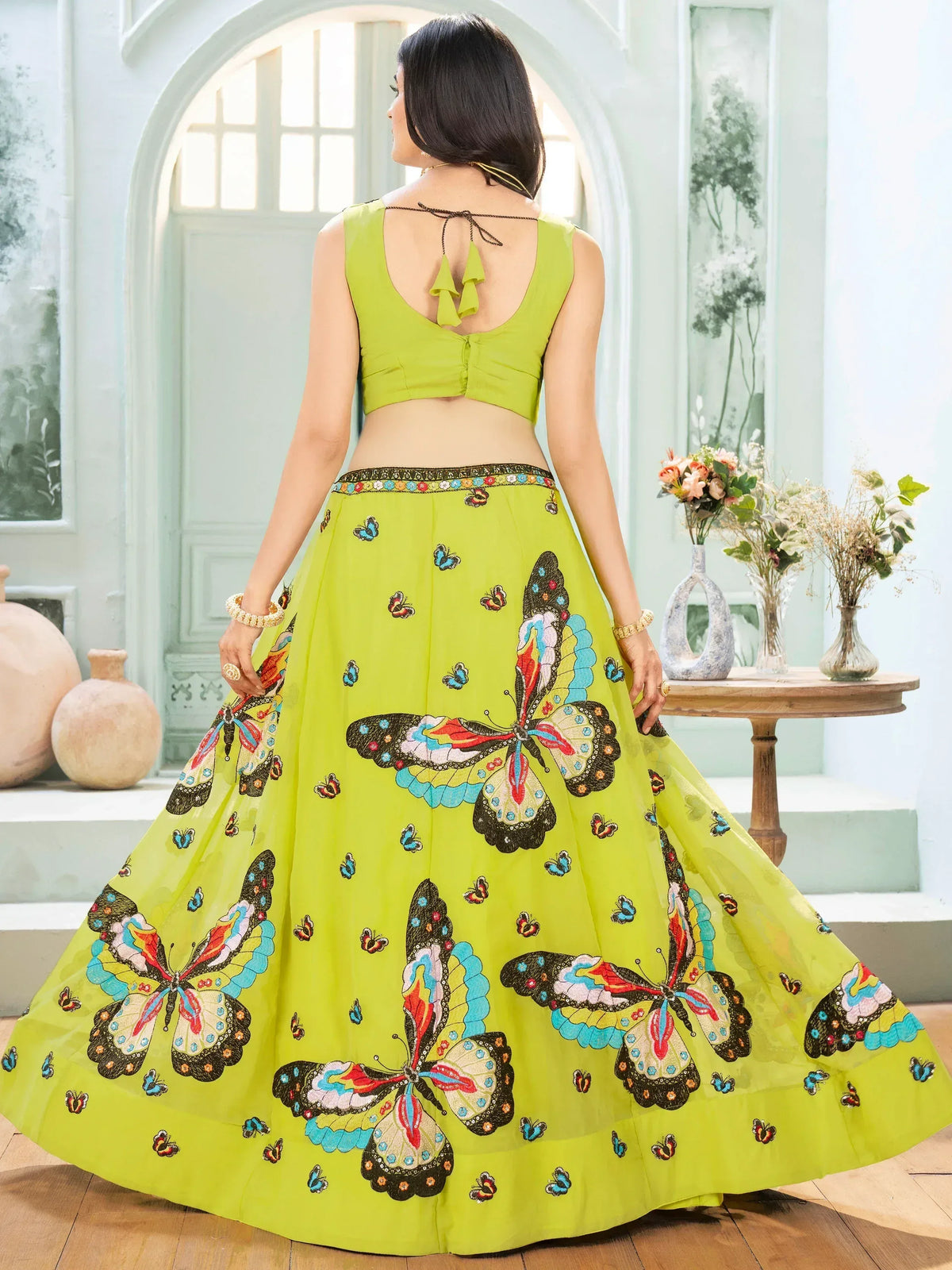 Lime green lehenga choli with colorful butterfly embroidery, back view