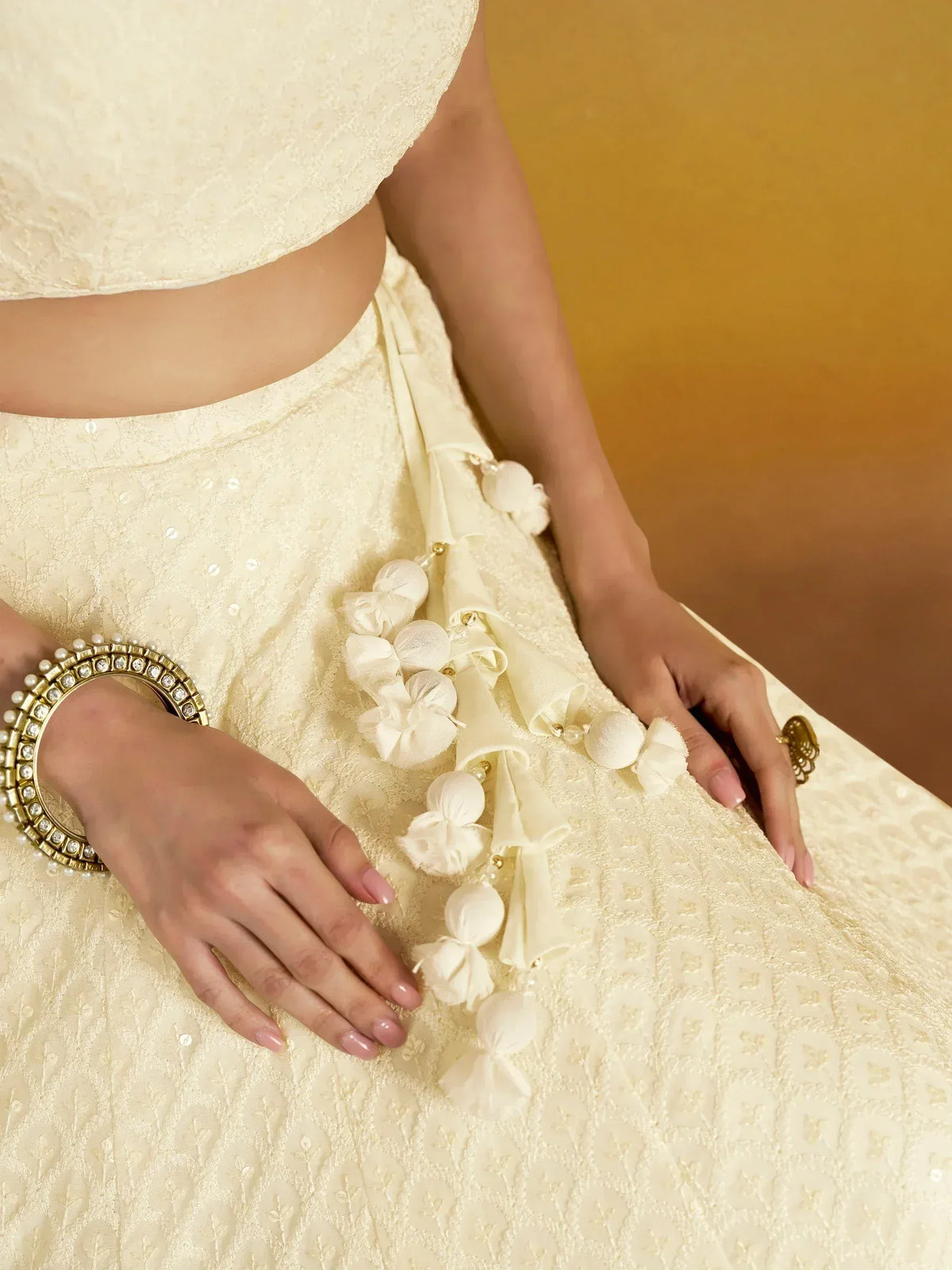Cream embroidered lehenga choli with floral tassels and pearl bangle, Indian ethnic wear