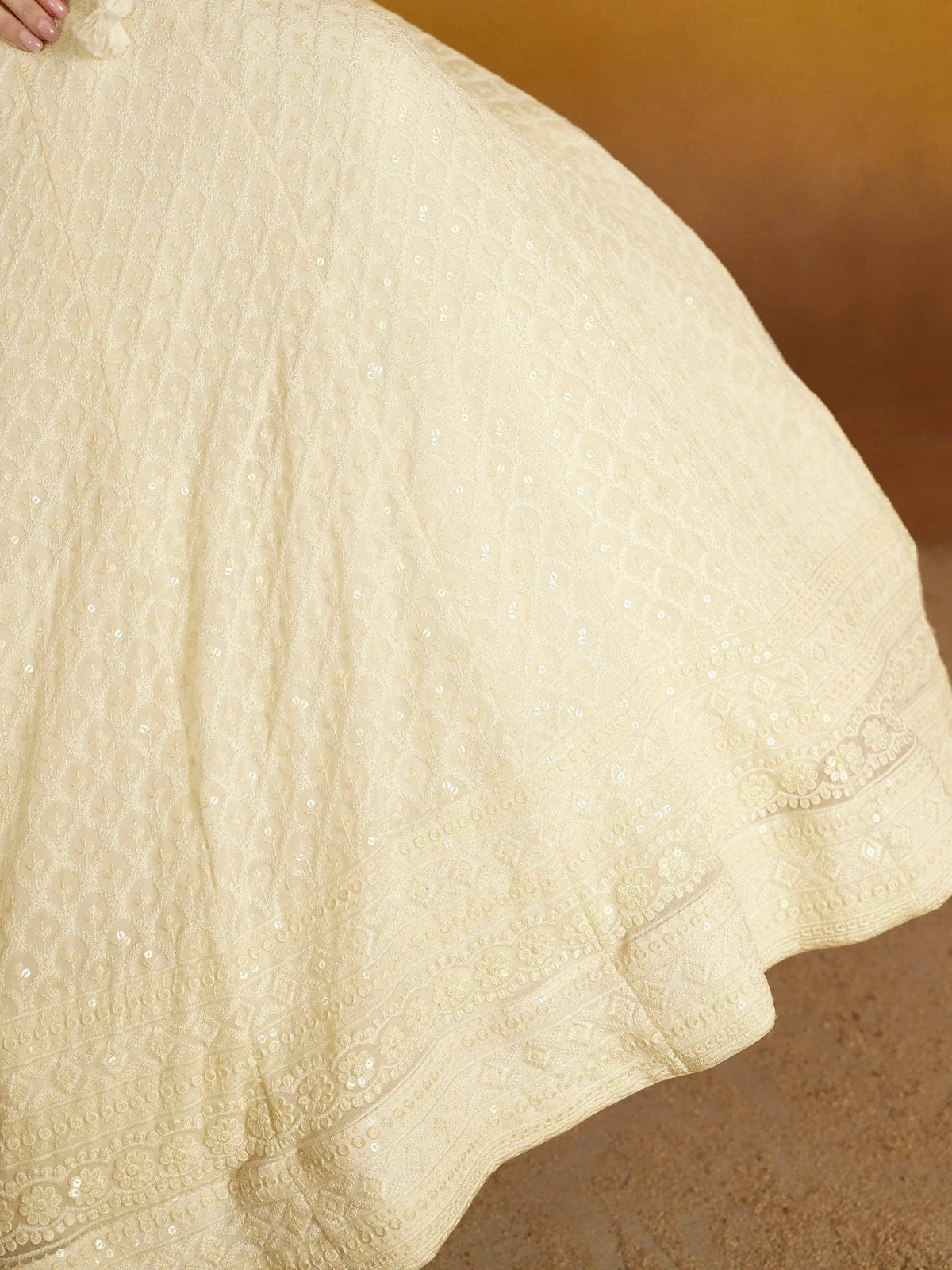 Cream embroidered lehenga with sequin detailing and floral border, perfect for Indian ethnic wear