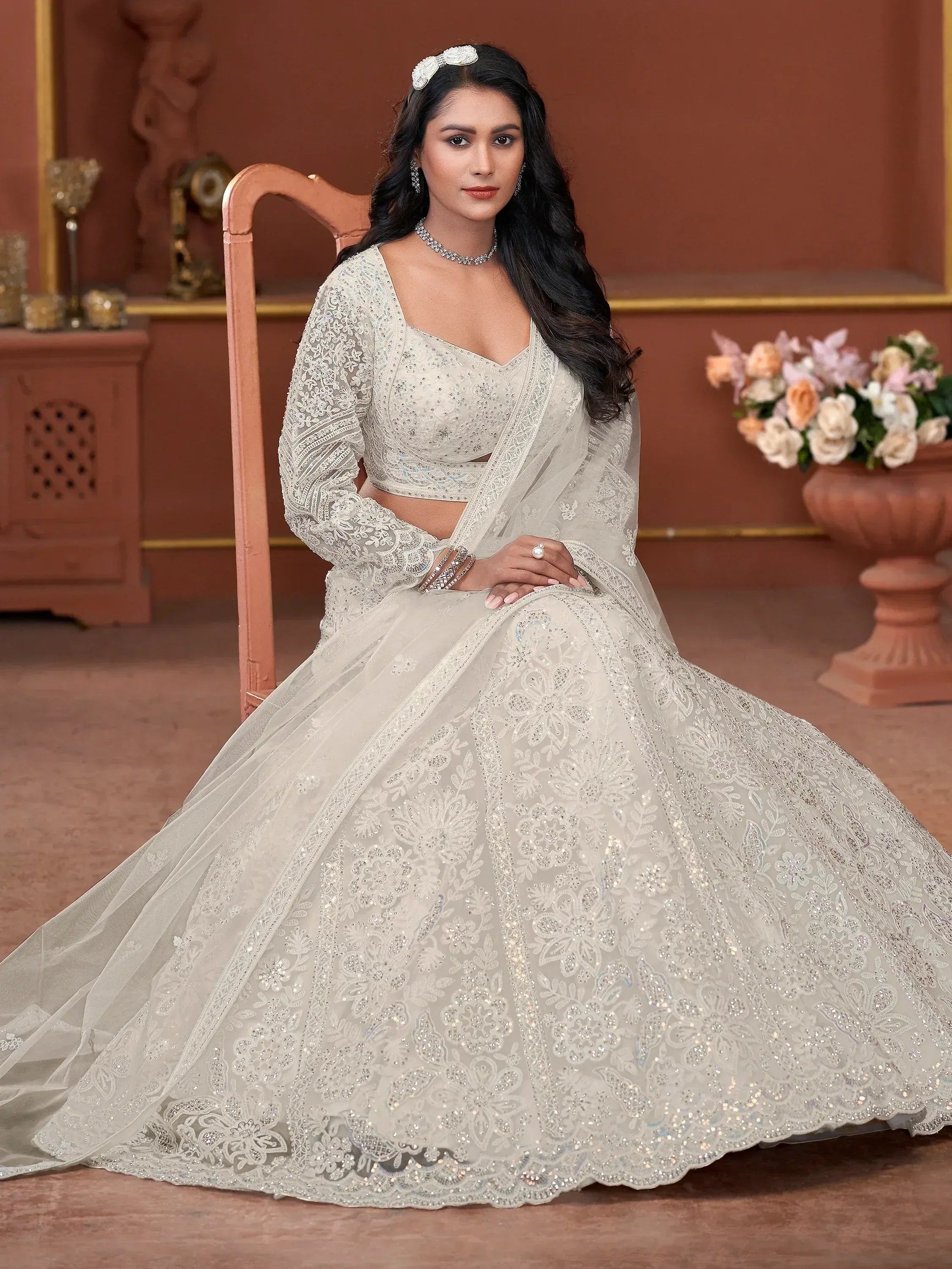 Elegant white embroidered lehenga choli with floral lace and sequins, perfect for Indian weddings and festive occasions.