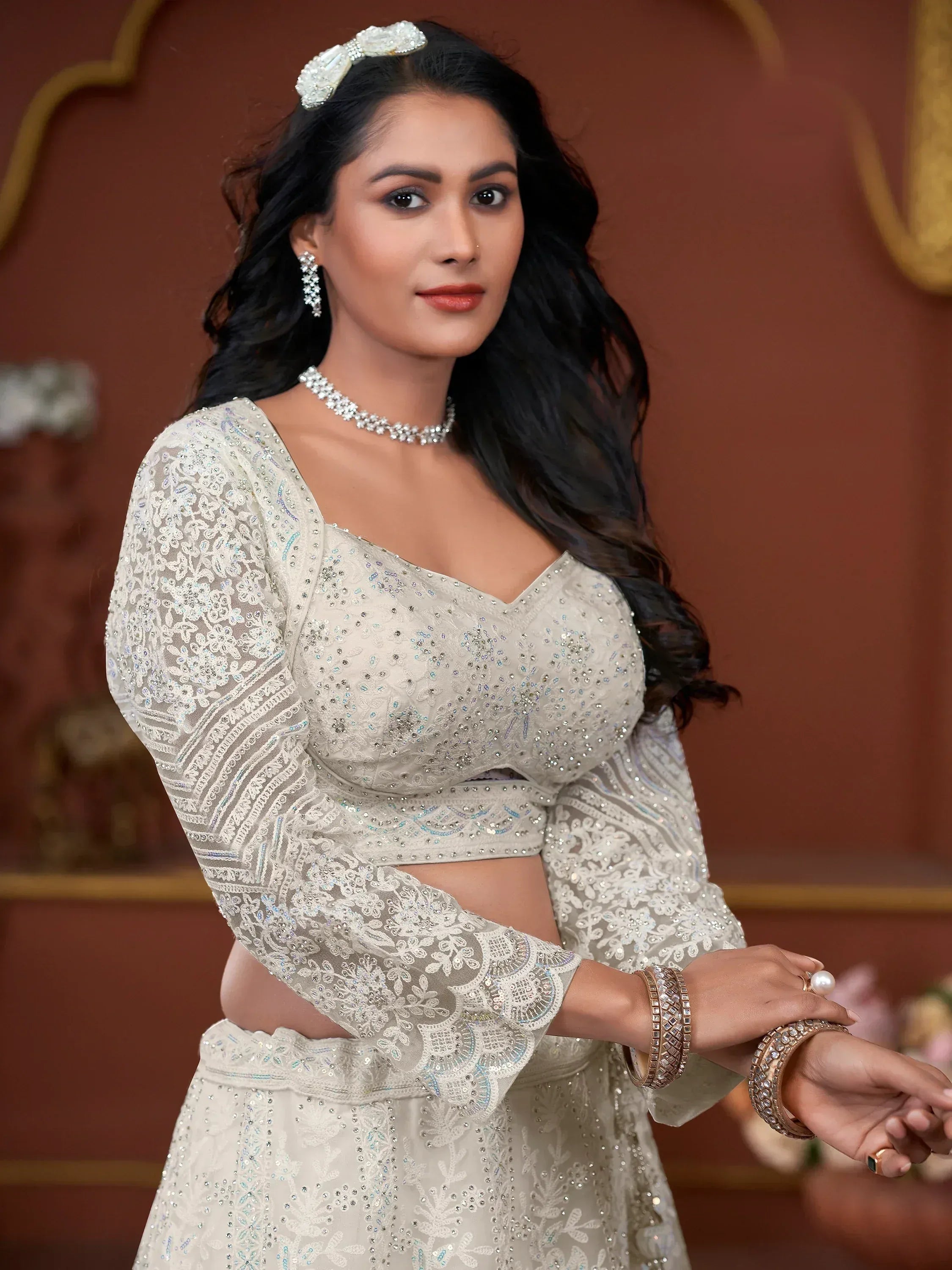 Elegant ivory designer lehenga choli with intricate lace and sequin work, perfect for Indian weddings and festive occasions.